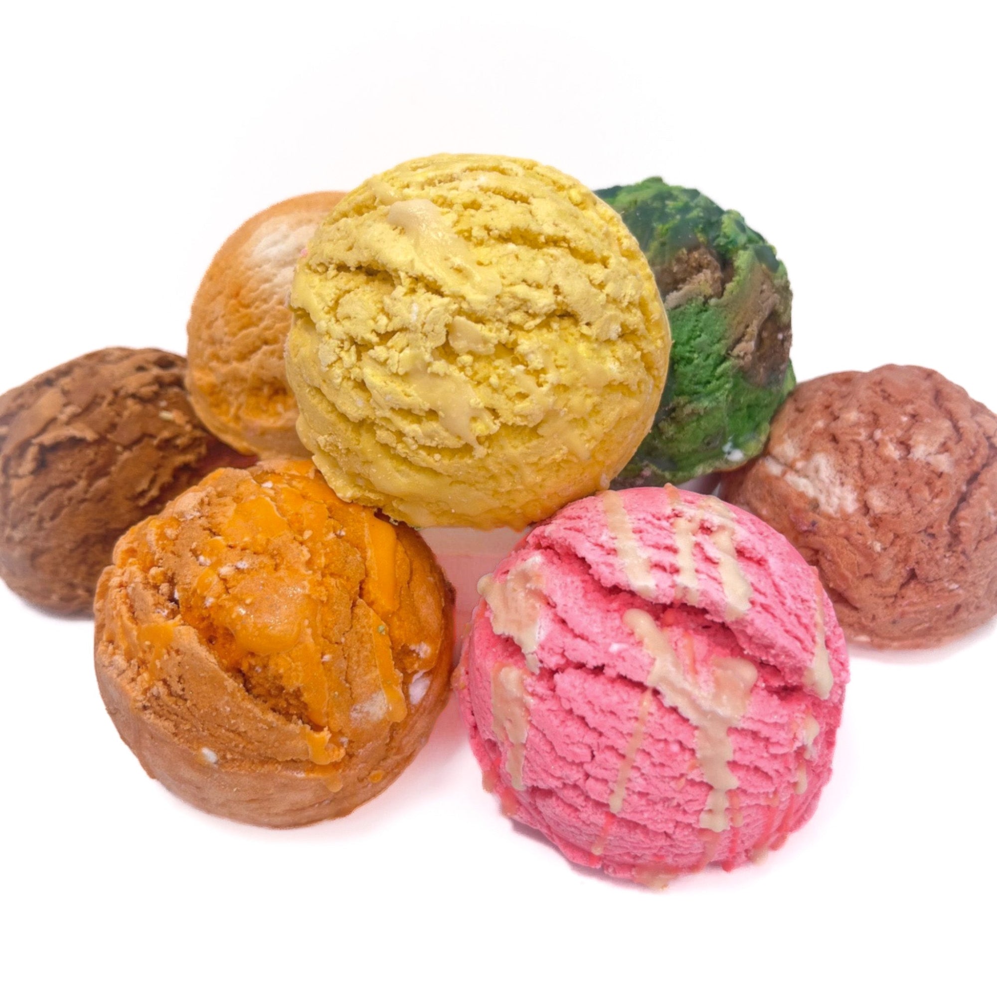 Multiple bubble bath scoops of various colors in a neat pile. 