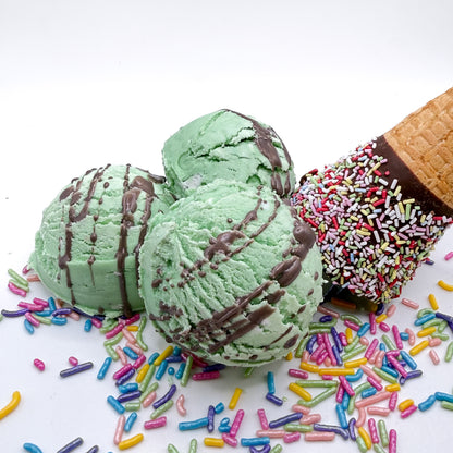 Three mint green with brown drizzle bubble bath scoops scented with mint chocolate chip Bubble scoops are hand made by Rusted Acre Soap Co and look like scoops of ice cream on a white background with sprinkles and an ice cream cone 
