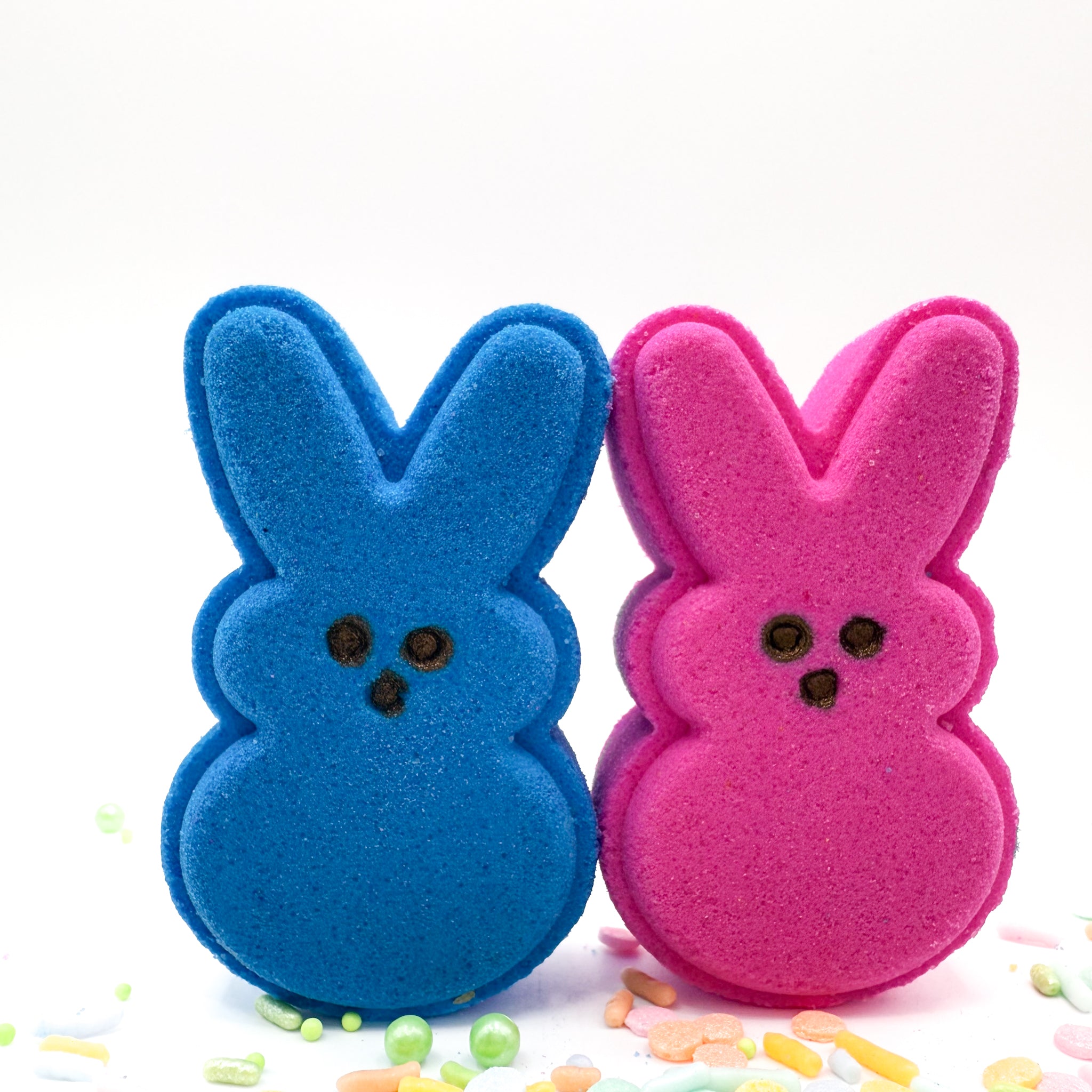 Two handmade bunny bath bombs by Rusted Acre Soap Co. One purple and one pink