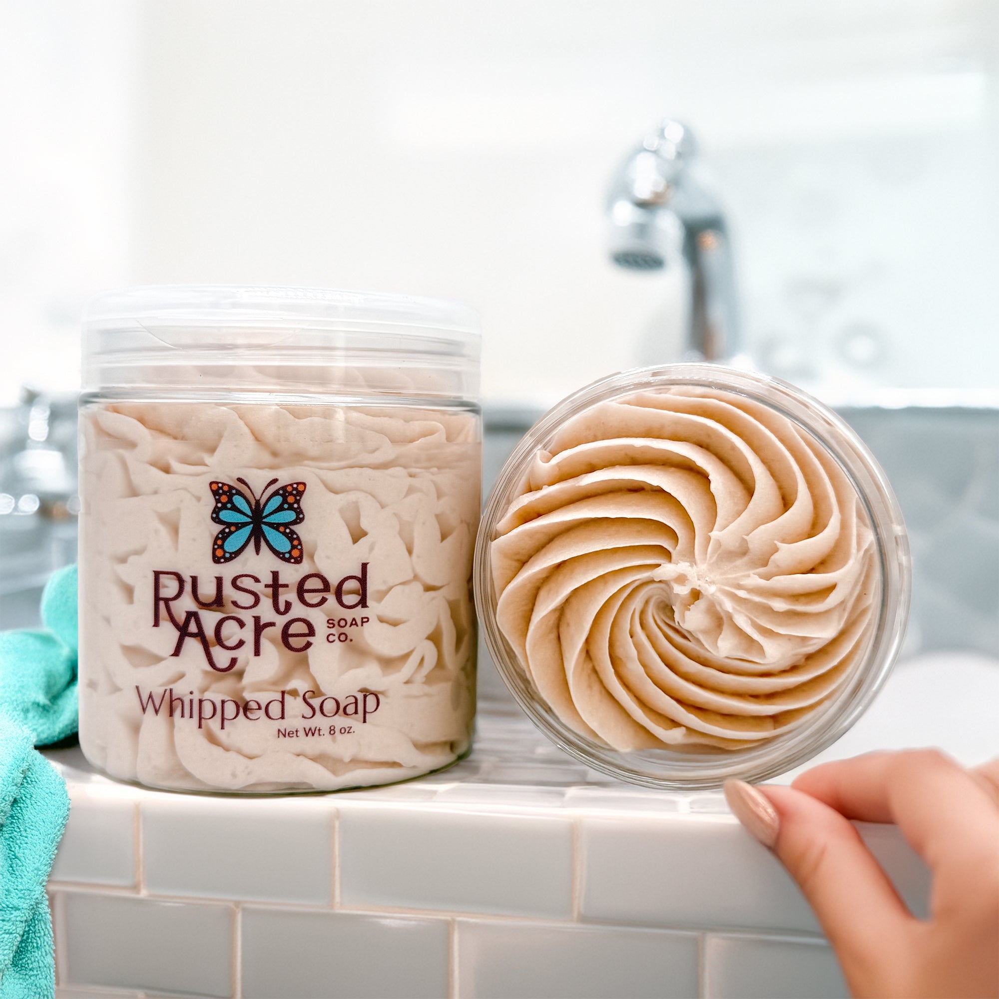 Two jars of Rusted Acre Soap Company's cashmere whipped soap in a lifestyle image.