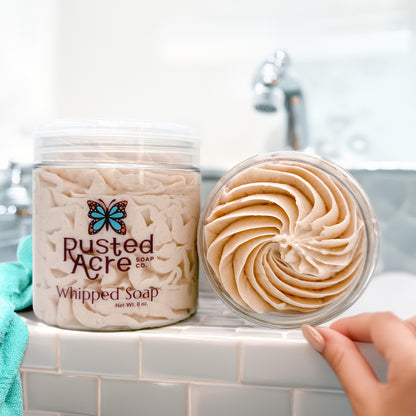 Two jars of Rusted Acre Soap Company's cashmere whipped soap in a lifestyle image.
