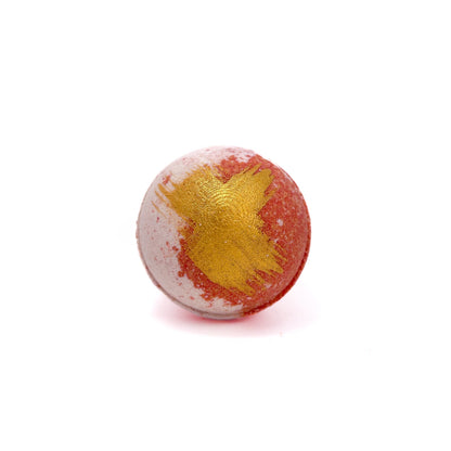Light red and white swirled bath bomb swiped gold accent on top.