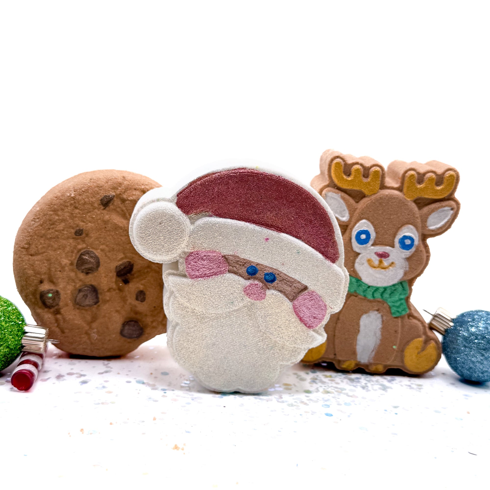 Handmade Christmas bath bomb set made by Rusted Acre Soap Co with santa, a deer, and a cookie. 