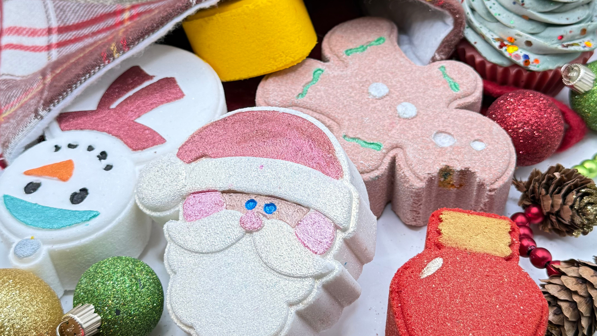 Assorted Christmas bath bombs with festive decorative elements. Happy Holidays from Rusted Acre Soap Co.