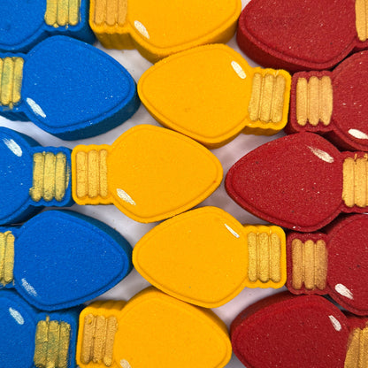 Colorful Christmas light bulb shaped bath bombs in red, yellow, and blue.