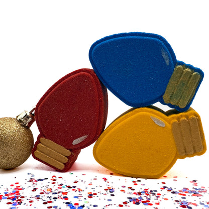 Three holiday light bulb bath bombs hand made by Rusted Acre Soap Co. Yellow, Red and Blue.