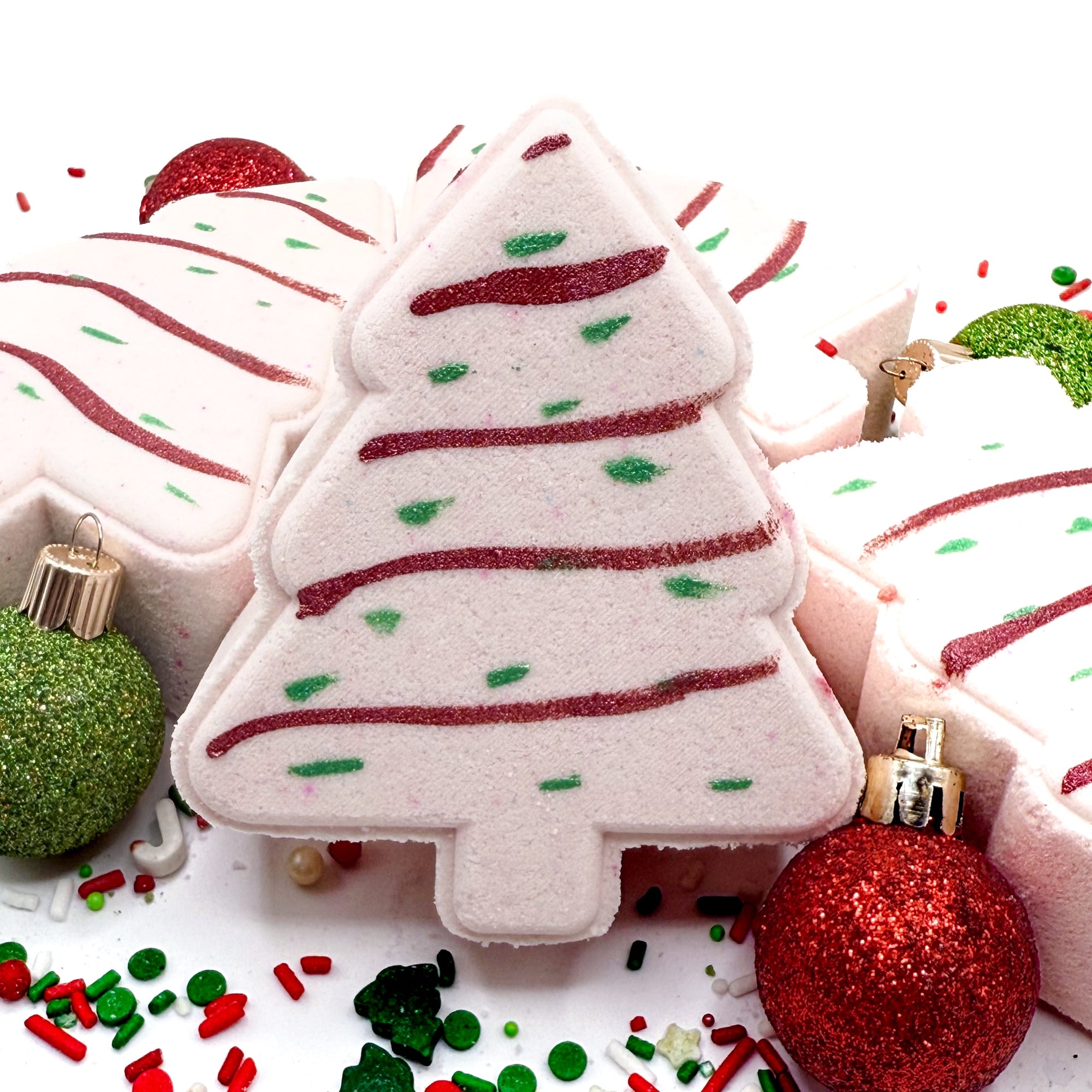 Christmas-tree shaped bath bombs handmade by Rusted Acre Soap Co with decorative elements on a white background