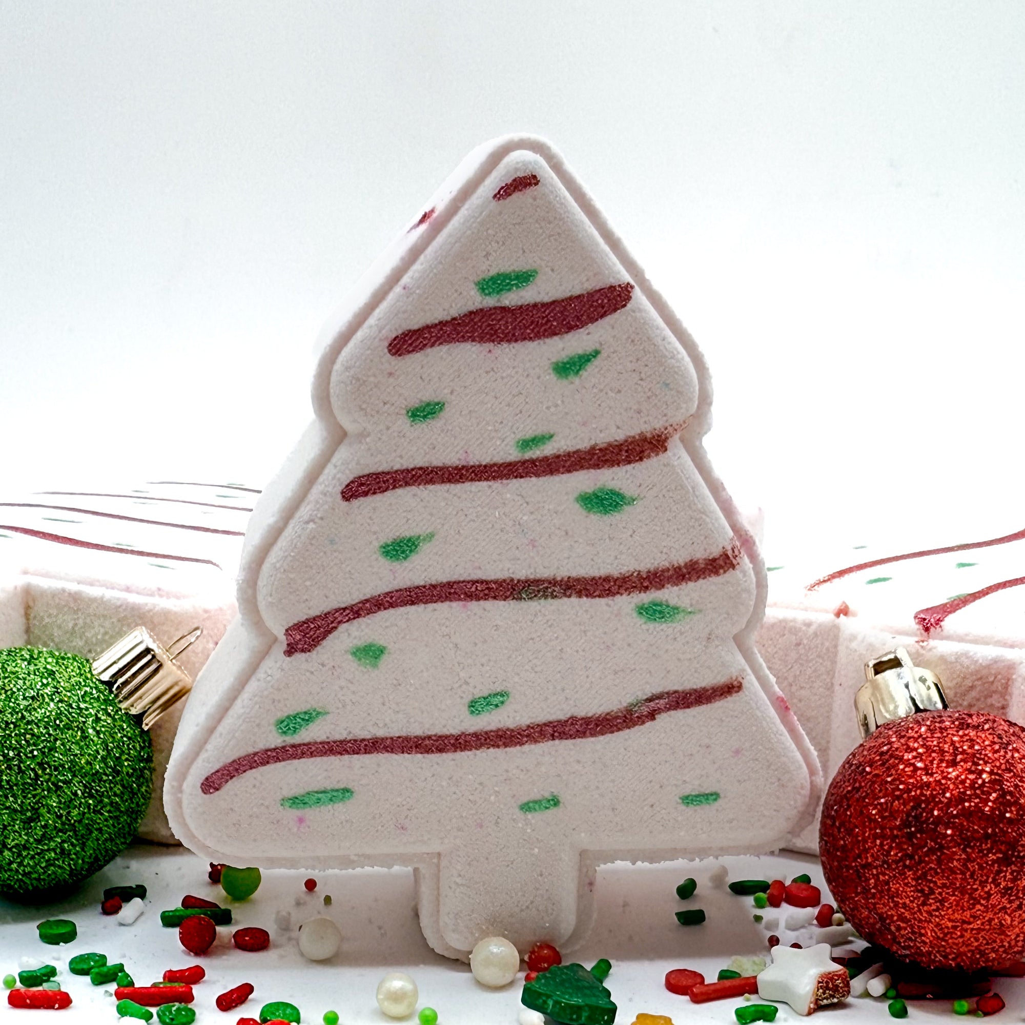 Decorative Christmas tree-shaped bath bomb with red and green accents on a white background