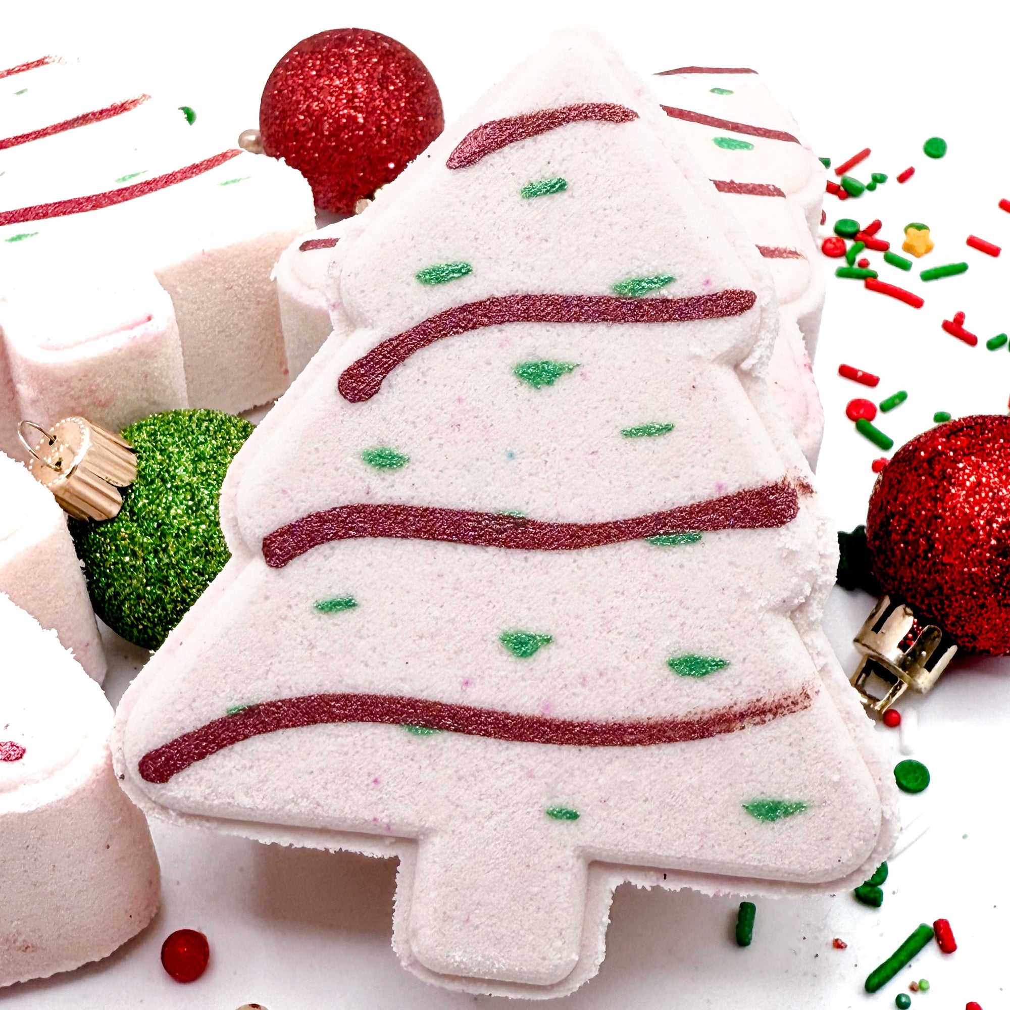 Christmas tree shaped bath bomb with festive decorations on a white background