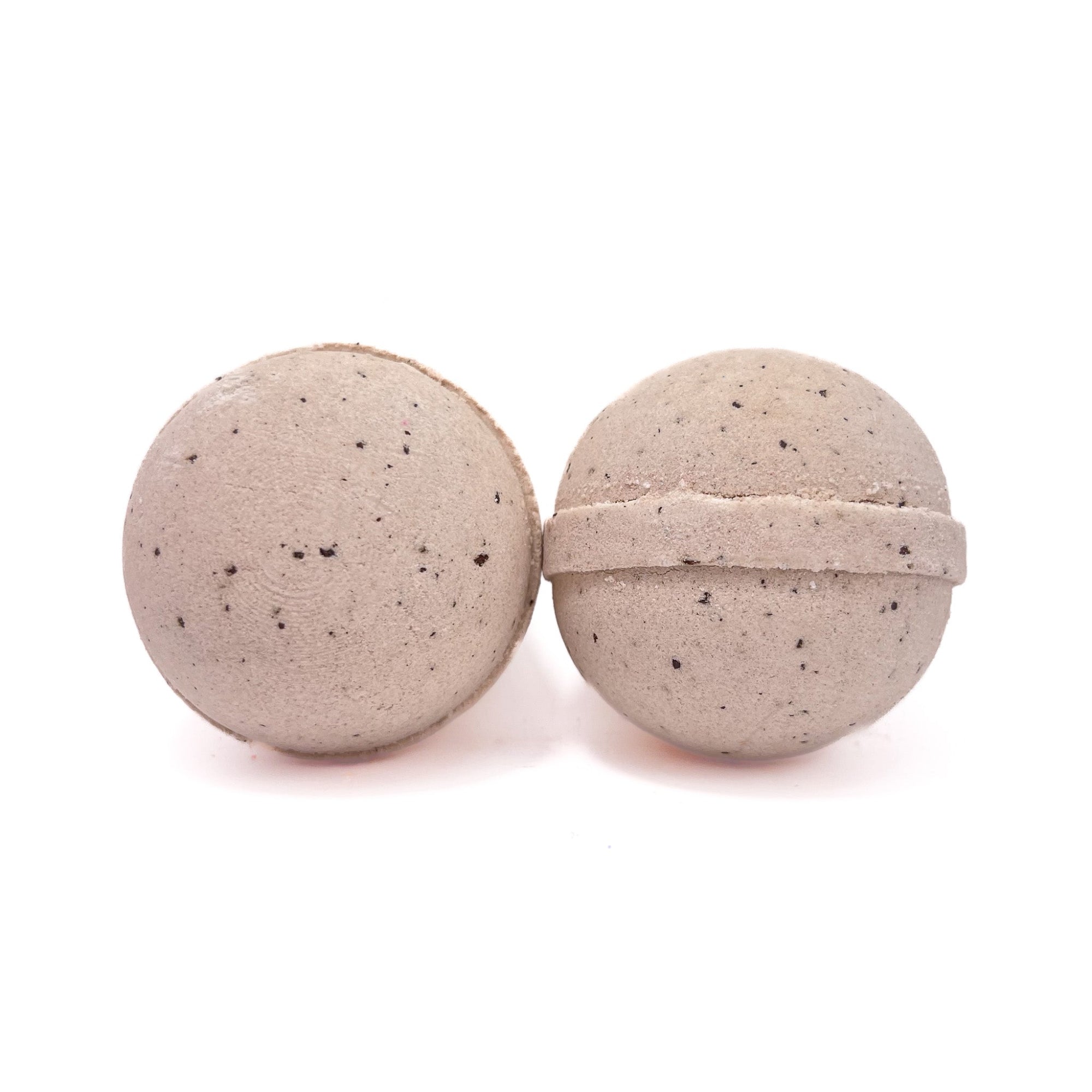 Two round coffee bath bombs lite tan in color with coffee bean specks throughout. 