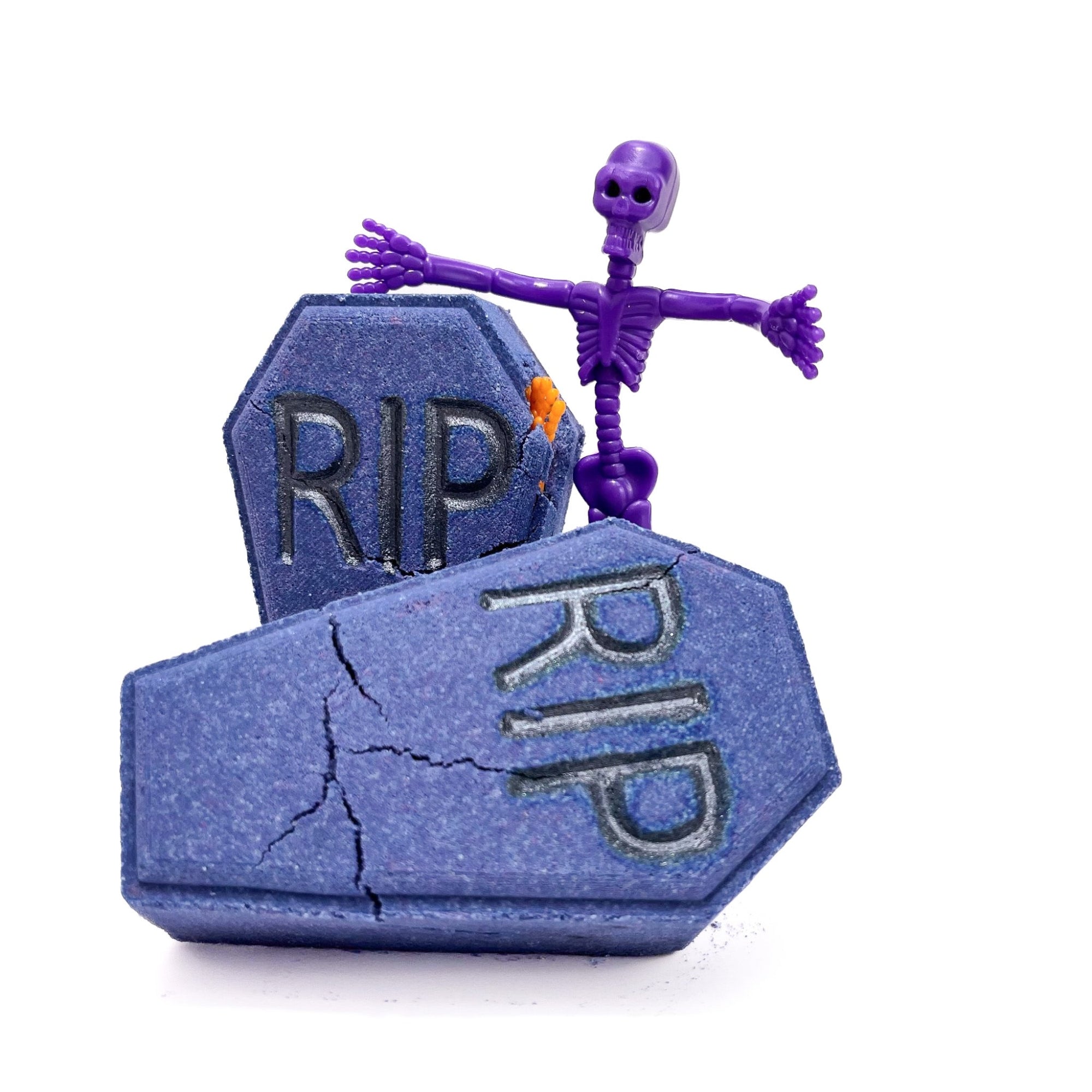 Two dark blue-purple coffins one with an orange hand sticking out. The letters RIP embossed on the front. Displayed with a purple rubber skeleton.