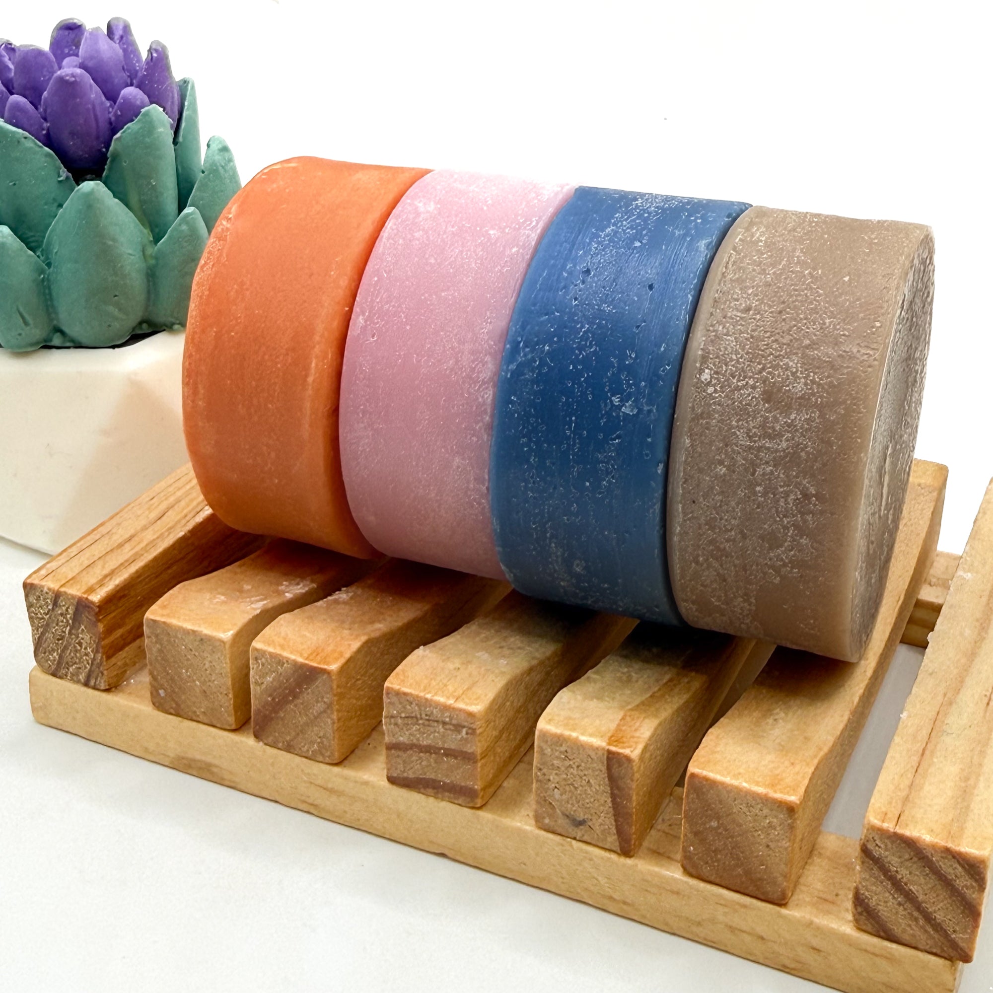 Colorful conditioner bars on a wooden stand with a white background