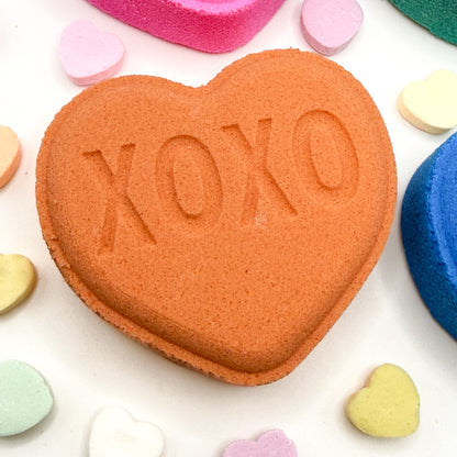 Heart shaped bath bomb with 'XOXO' embossed on a white background