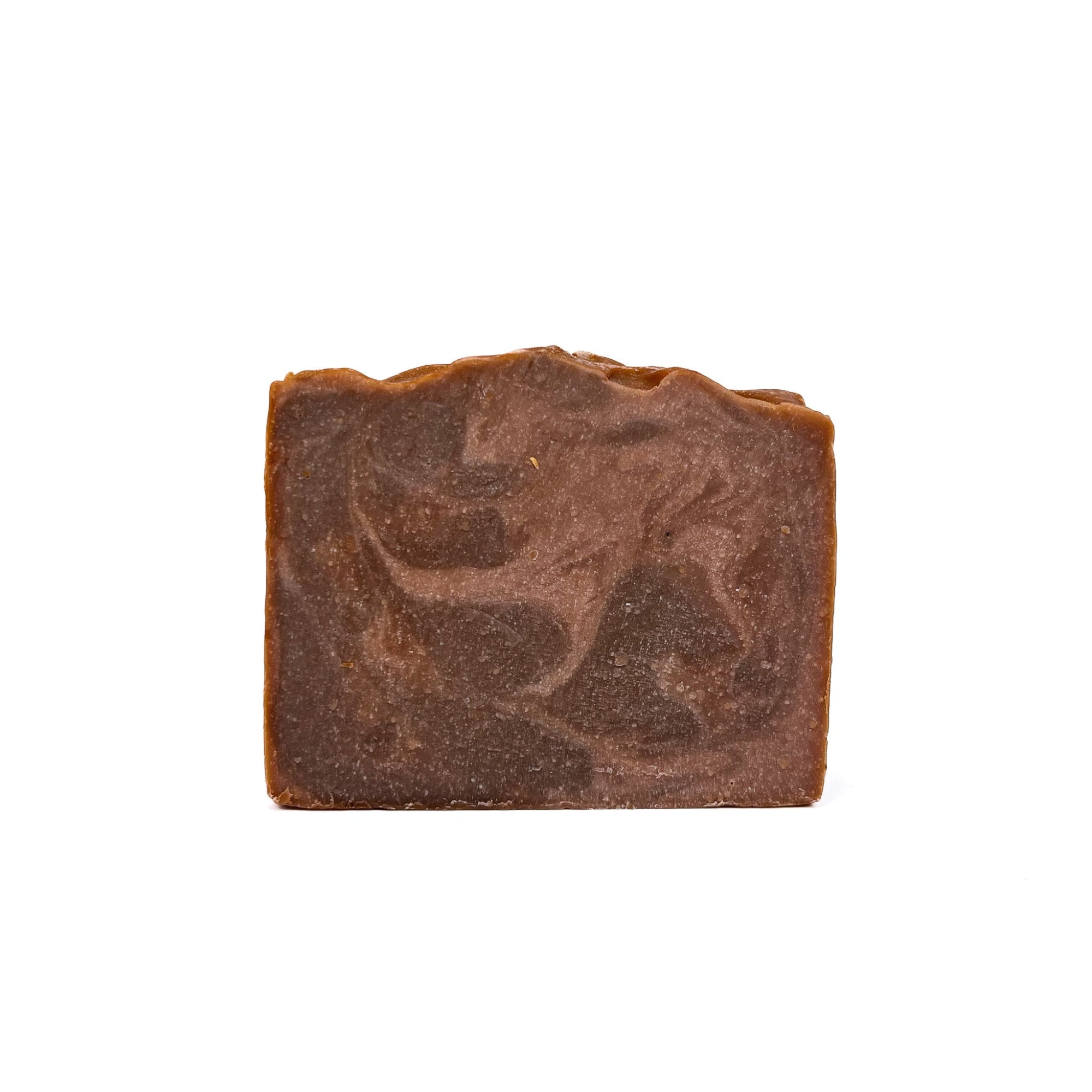 A bar of Rusted Acre Soap Company's Cowboy handmade soap. Colors are swirled dark brown and light brown like leather!