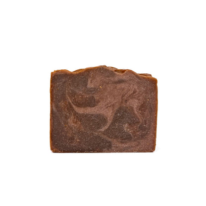 A bar of Rusted Acre Soap Company's Cowboy handmade soap. Colors are swirled dark brown and light brown like leather!