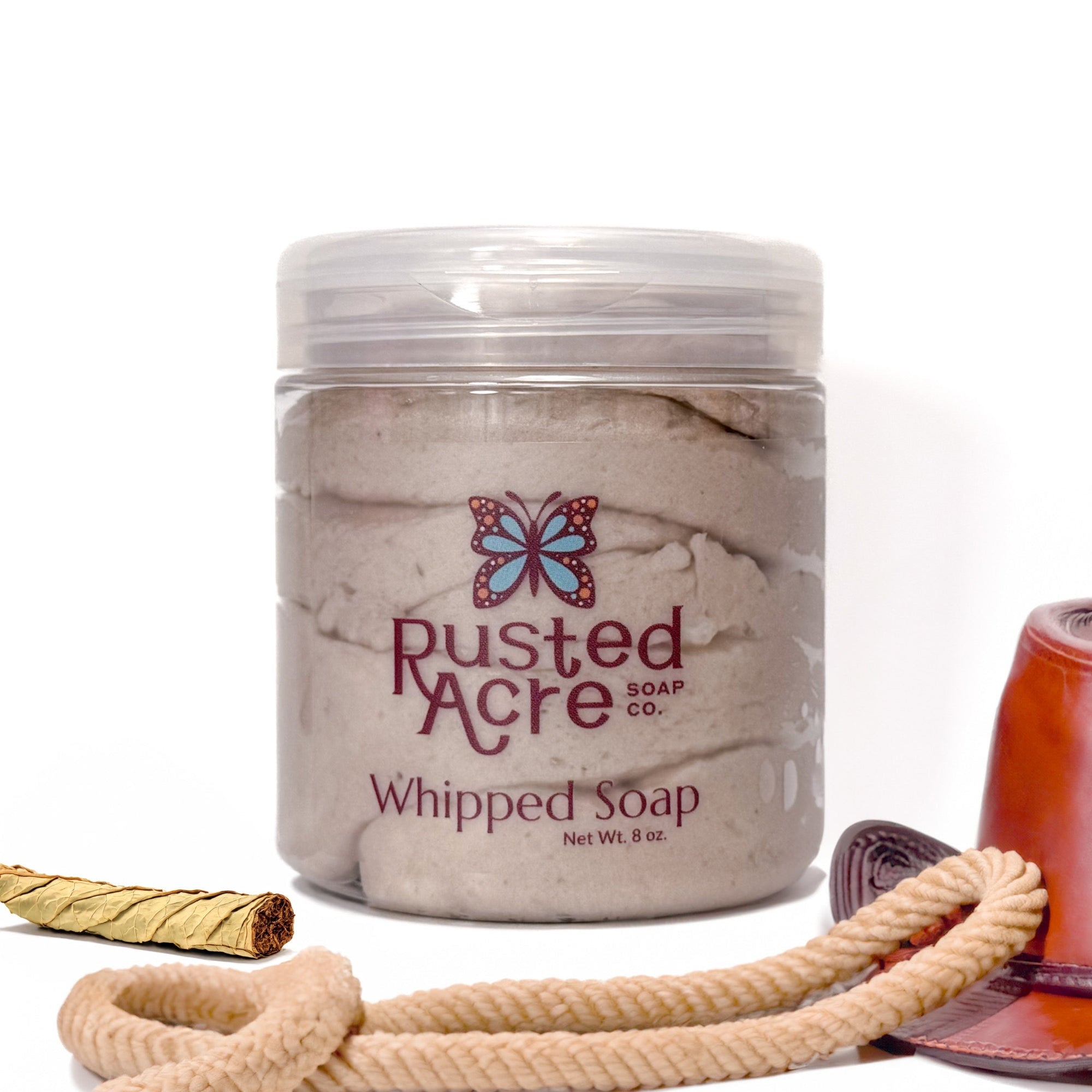 Jar of Rusted Acre Soap Company's vegan cowboy whipped soap. brown soap in a reusable plastic jar in a lifestyle setting. 