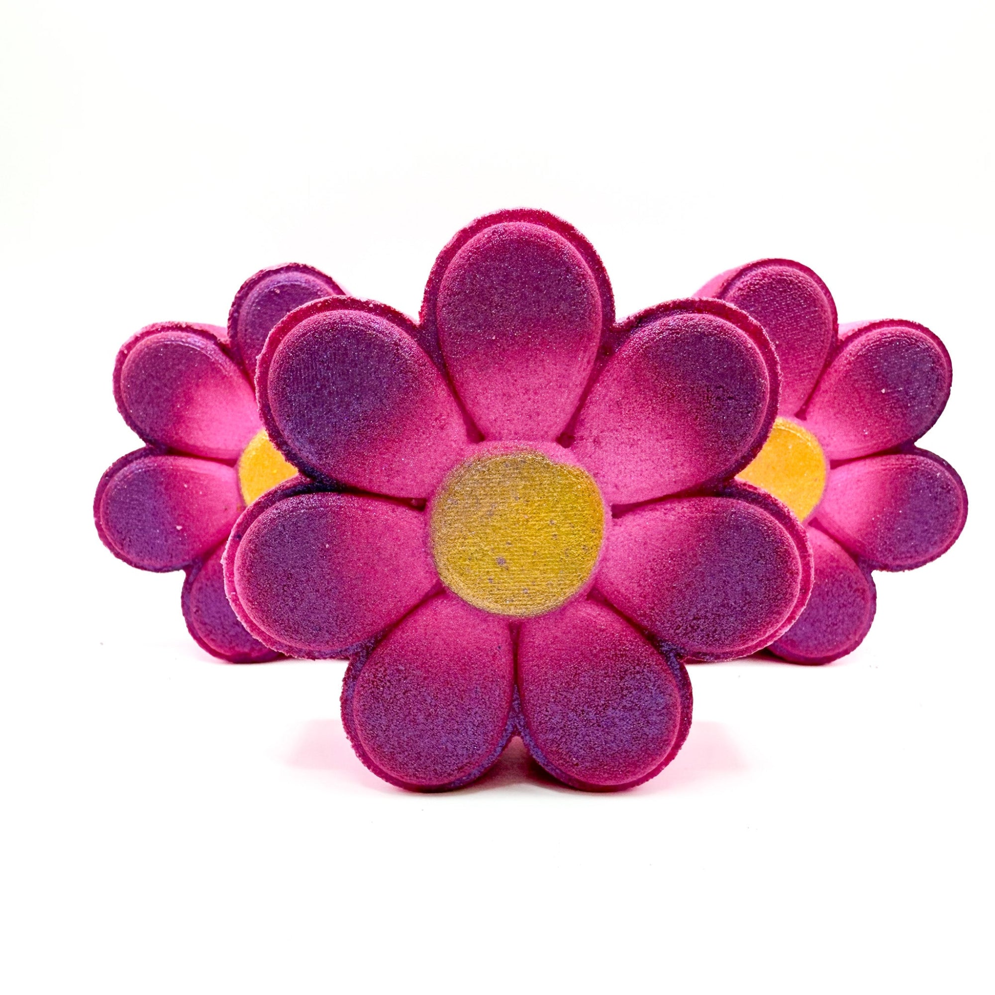 Up close view of Rusted Acre Soap Companies daisy bath bomb. Pink with a gold center.