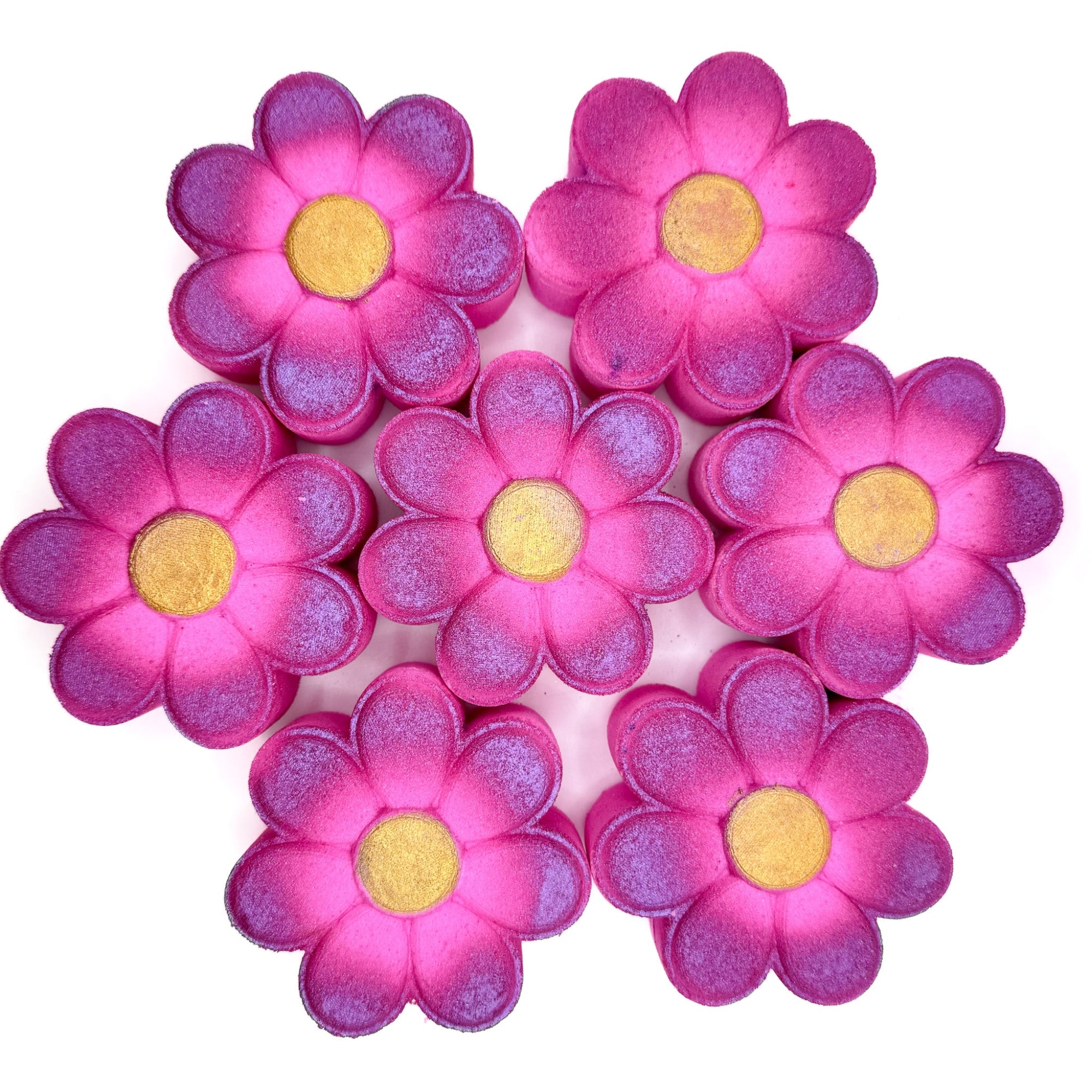 Multiple daisy bath bombs made by Rusted Acre Soap Company. Pink and gold daisy shaped flower,