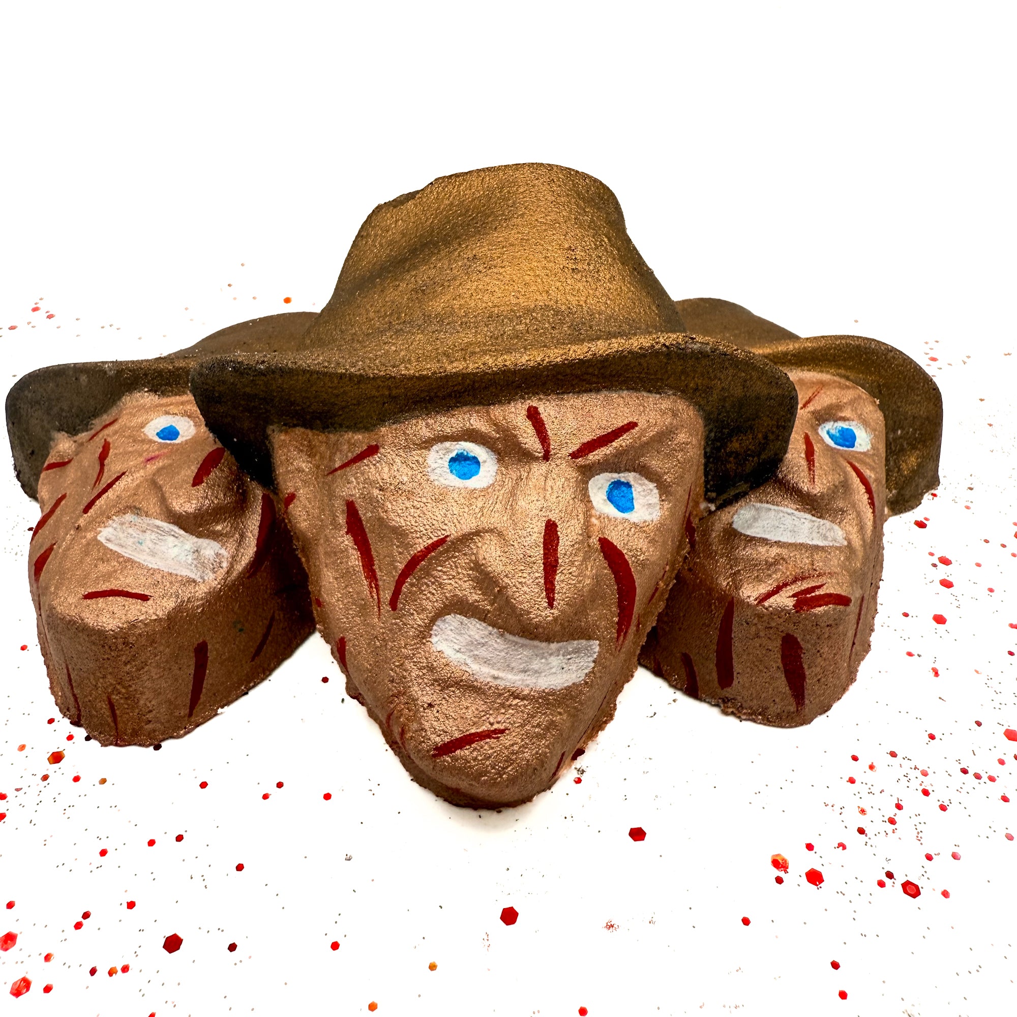 Group of Dream Hunter horror movie-inspired bath bombs arranged on blood-splatter background, showcasing handcrafted design and painted details. Made by Rusted Acre Soap Company. 