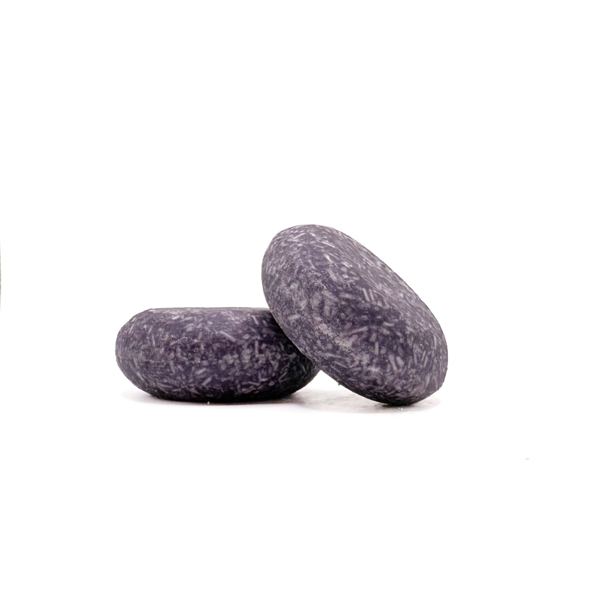 Two purple zero waste shampoo bars in enchanted scent from Rusted Acre Soap Company. 