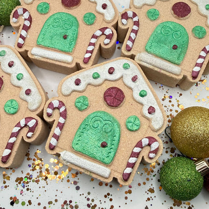 Hand painted gingerbread house with Christmas decorations surrounding it. 
