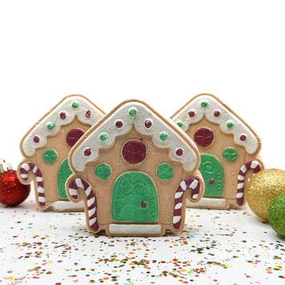Three hand painted gingerbread house bath bombs on a white background. 