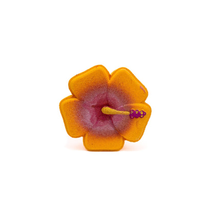 A orange hibiscus shaped bath bomb. Hand-painted yellow center.