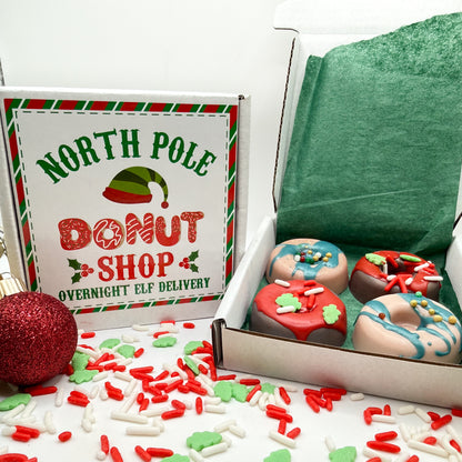 A box of mini holiday donut soaps from Rusted Acre Soap Co. Soaps are brown and tan with red or green drizzle. Box labeled North Pole Donut Shop.