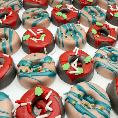 Assorted mini donut soap handmade by Rusted Acre Soap Co with red and green icing holiday sprinkles on a white background.