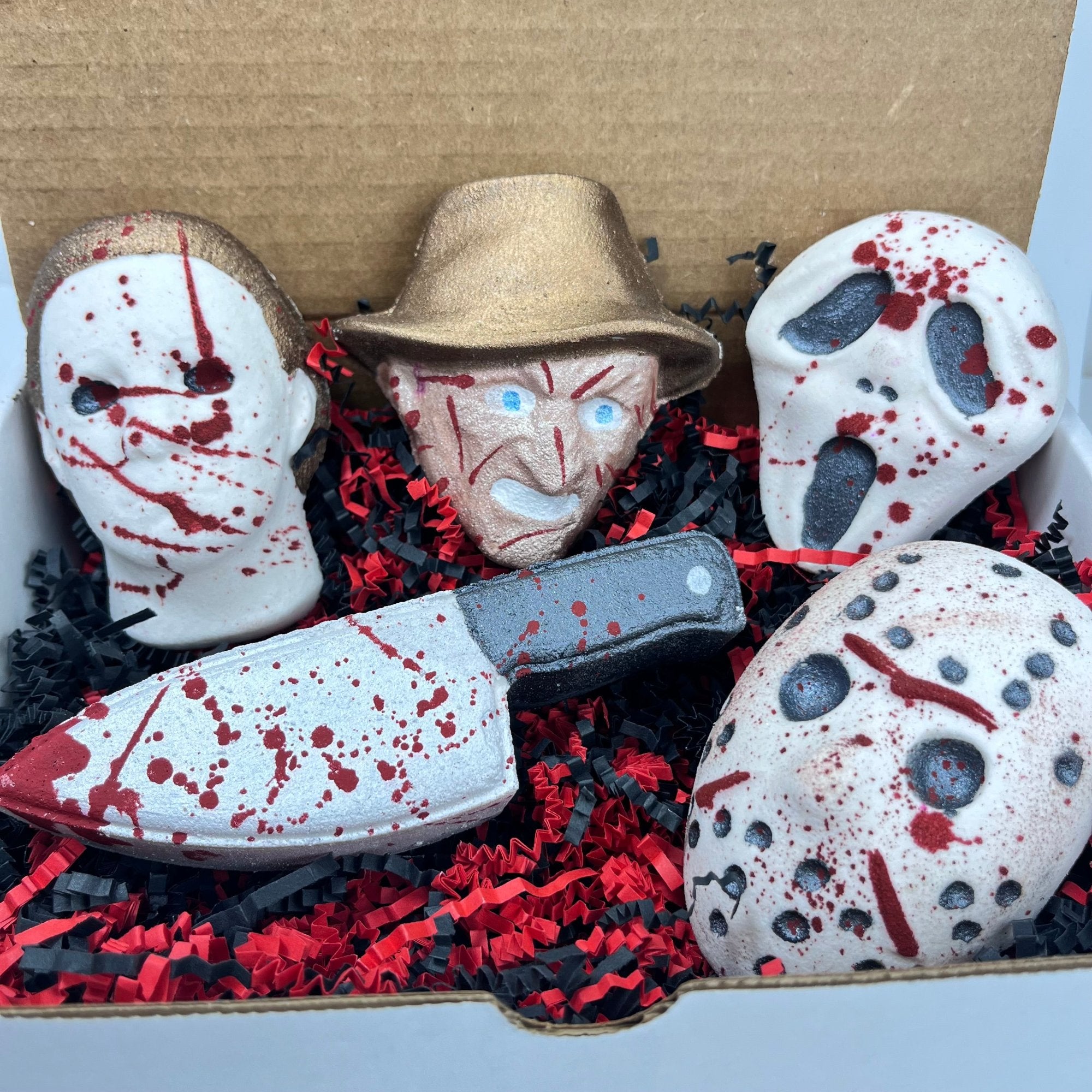 Rusted Acre Soap Company's full horror box bath bomb set displayed in a box with red and black crinkle paper. This is how it is shipped, with extra padding of course!