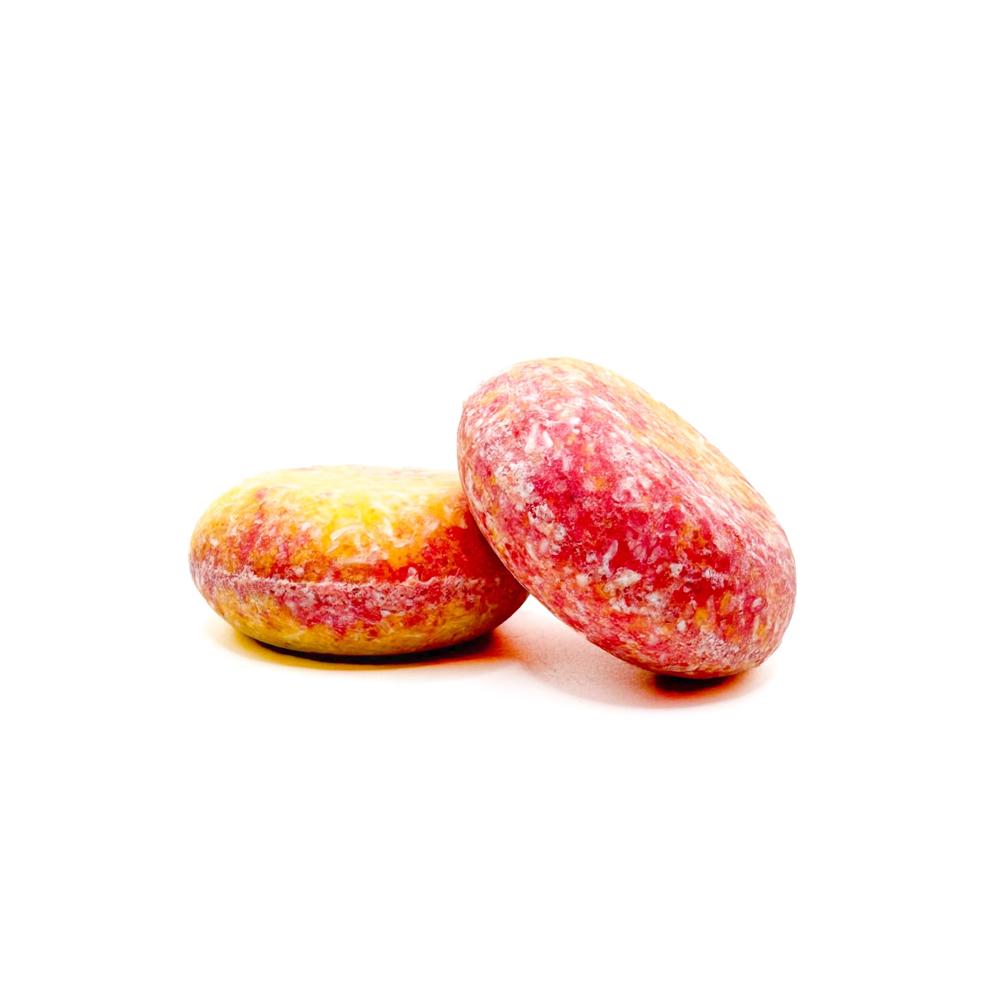 Two round red and yellow swirled island hibiscus shampoo bars handmade by Rusted Acre Soap Co.