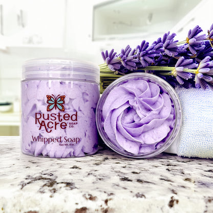 Two jars of lavender whipped soap from rusted acre soap company in a bathroom scene.