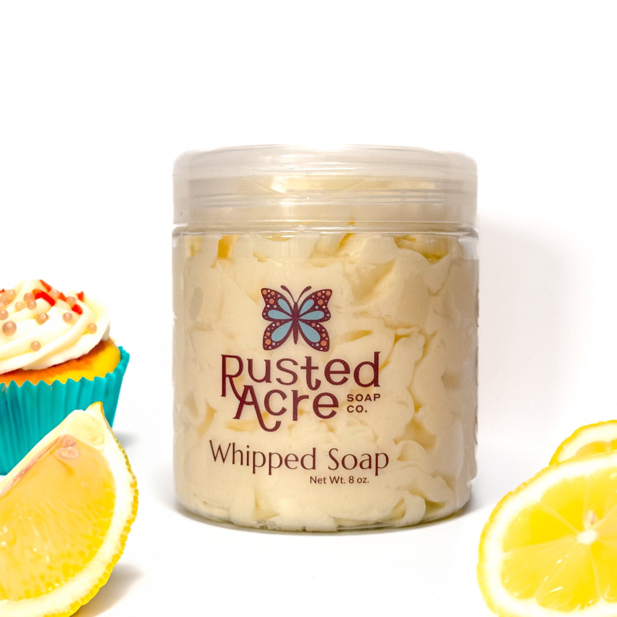 Jar of Rusted Acre Soap Company's vegan lemon cupcake whipped soap. Yellow soap in a reusable plastic jar in a lifestyle setting. 