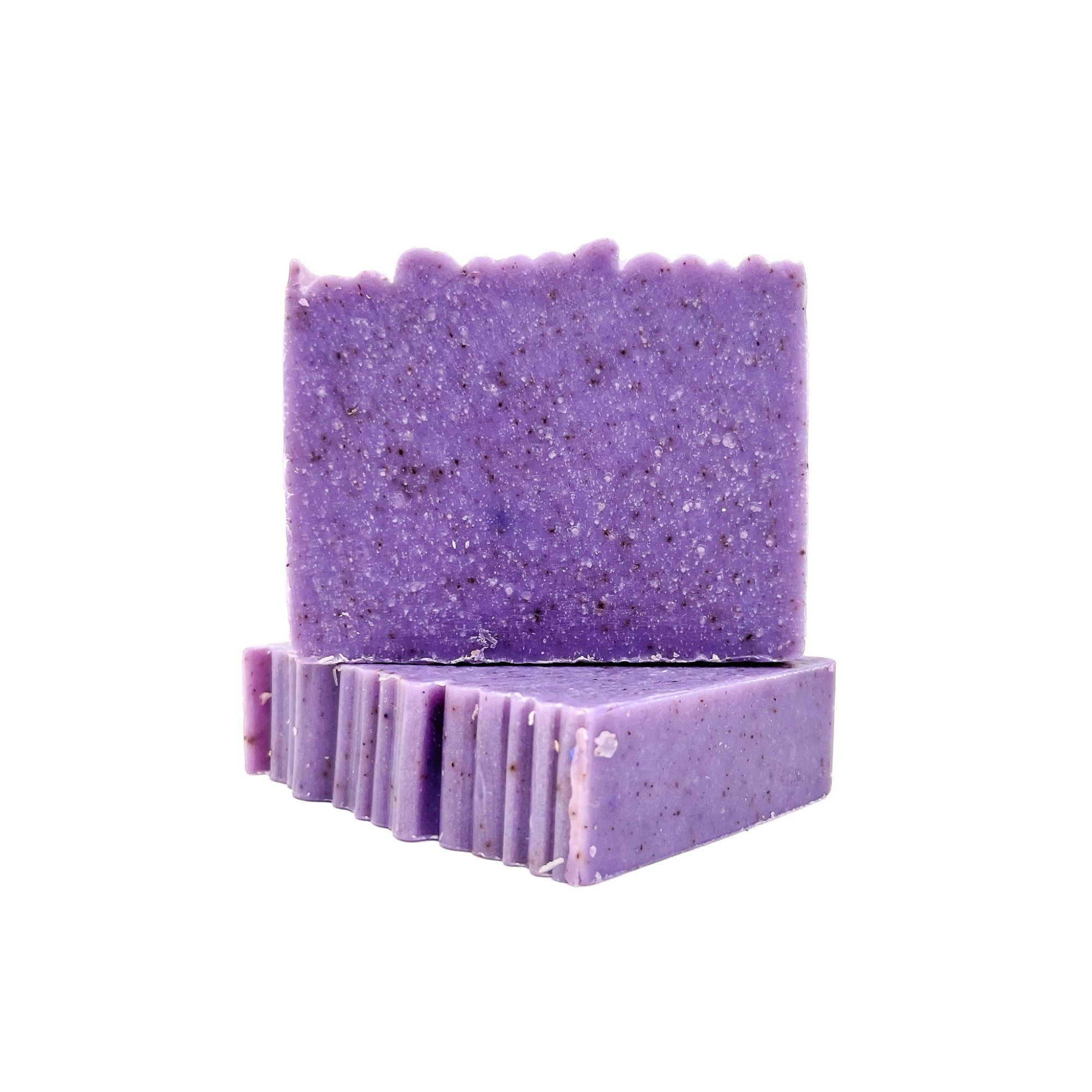Two bars of handmade lilac purple soap with textured top from Rusted Acre Soap Company. 