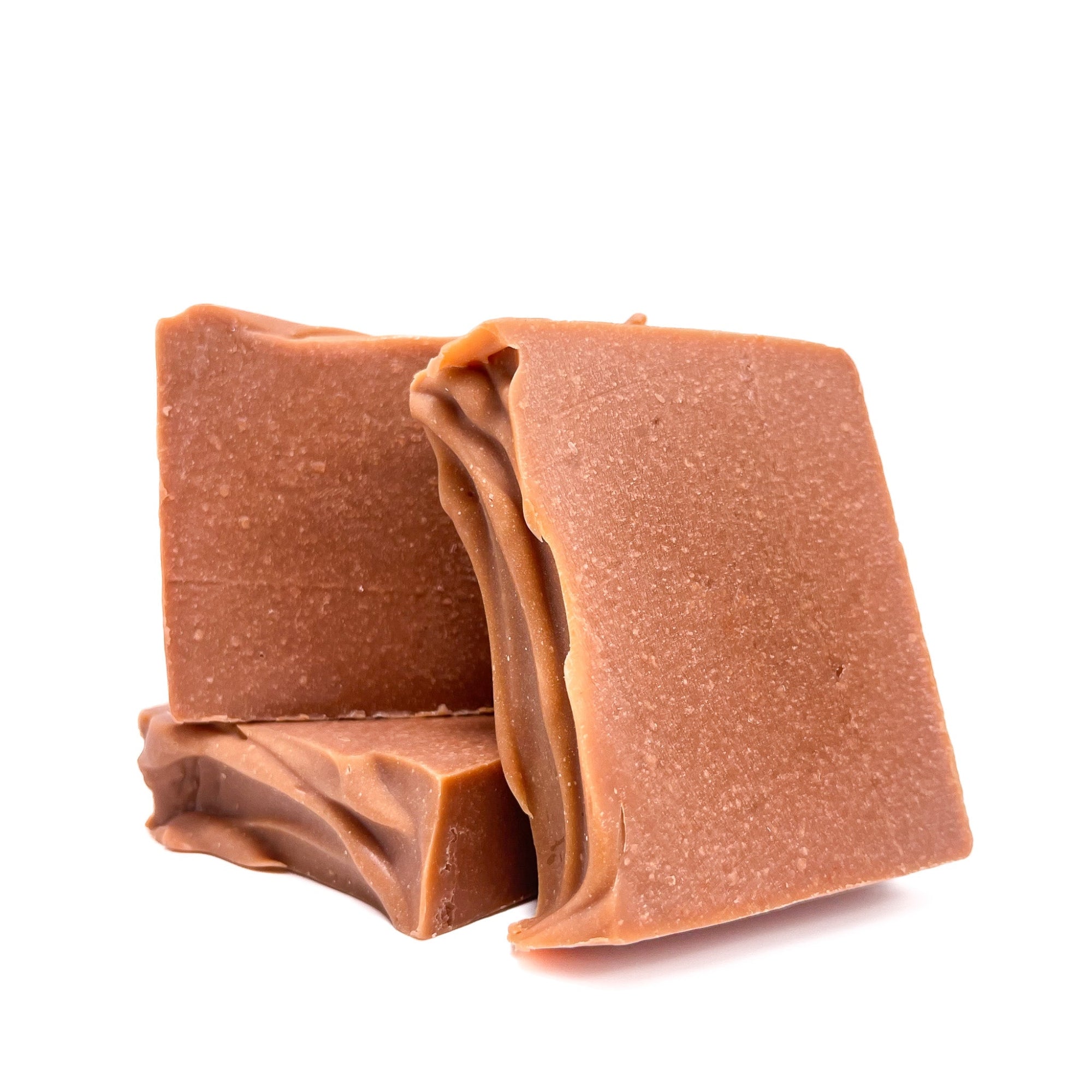Three bars of brownish-red handmade soap. One flat, two upright to show texture. 