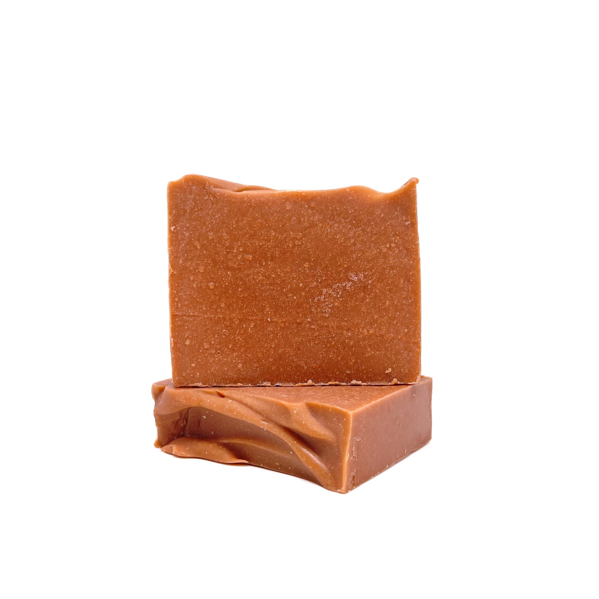 Two bars of Rusted Acre Soap Company's Mahogany handmade soap. Color is brownish-red. One flat, one upright to show texture. 