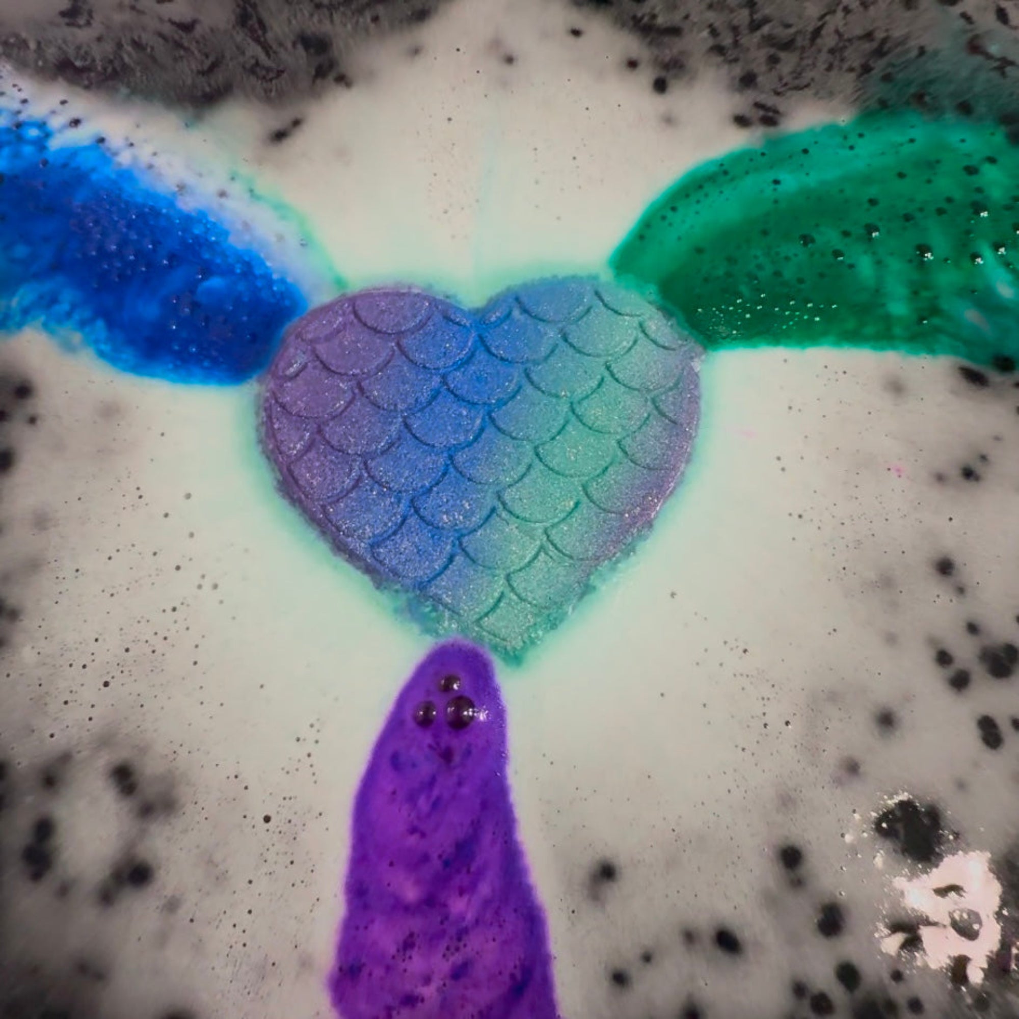 Rusted Acre Soap Companies Mermaid Heart bath bomb putting on a color show.