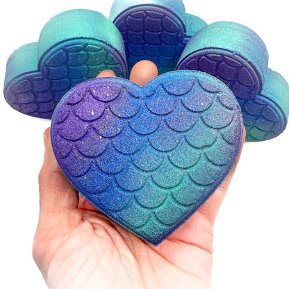 Mermaid heart bath bombs made by Rusted Acre Soap Company in hand.