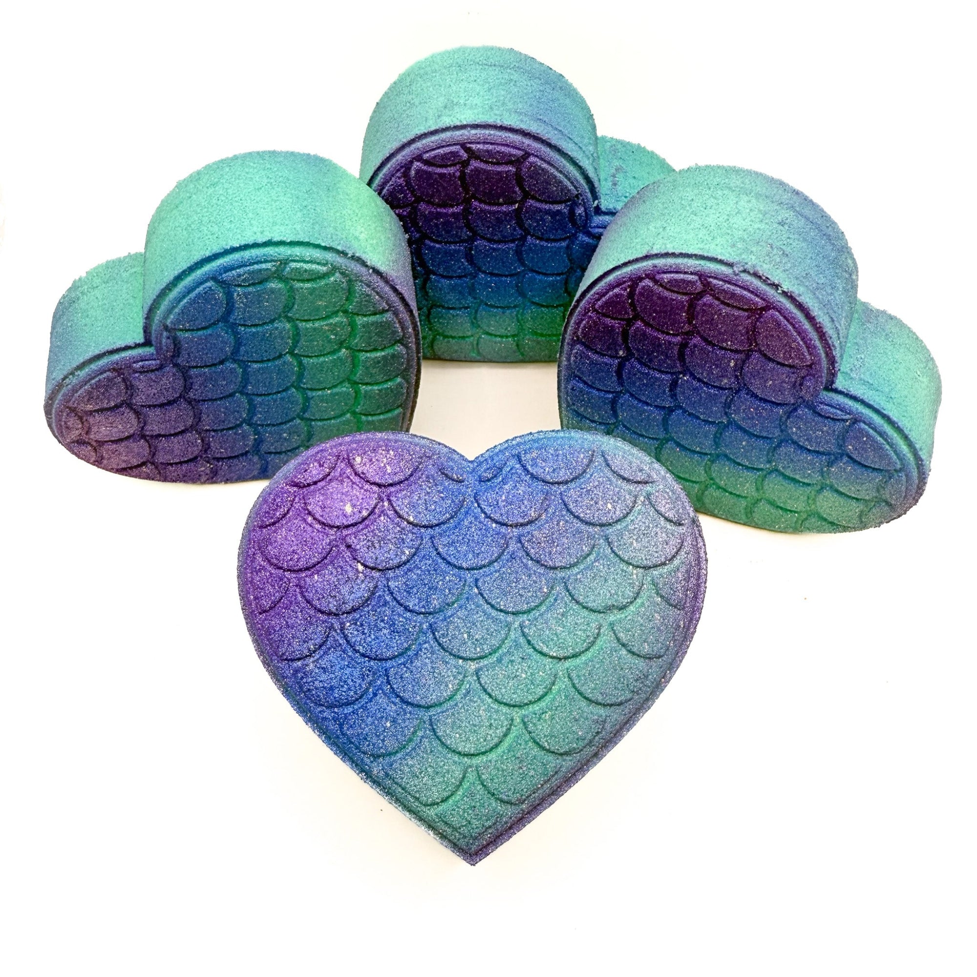 Multiple mermaid heart bath bombs made by Rusted Acre Soap Company.