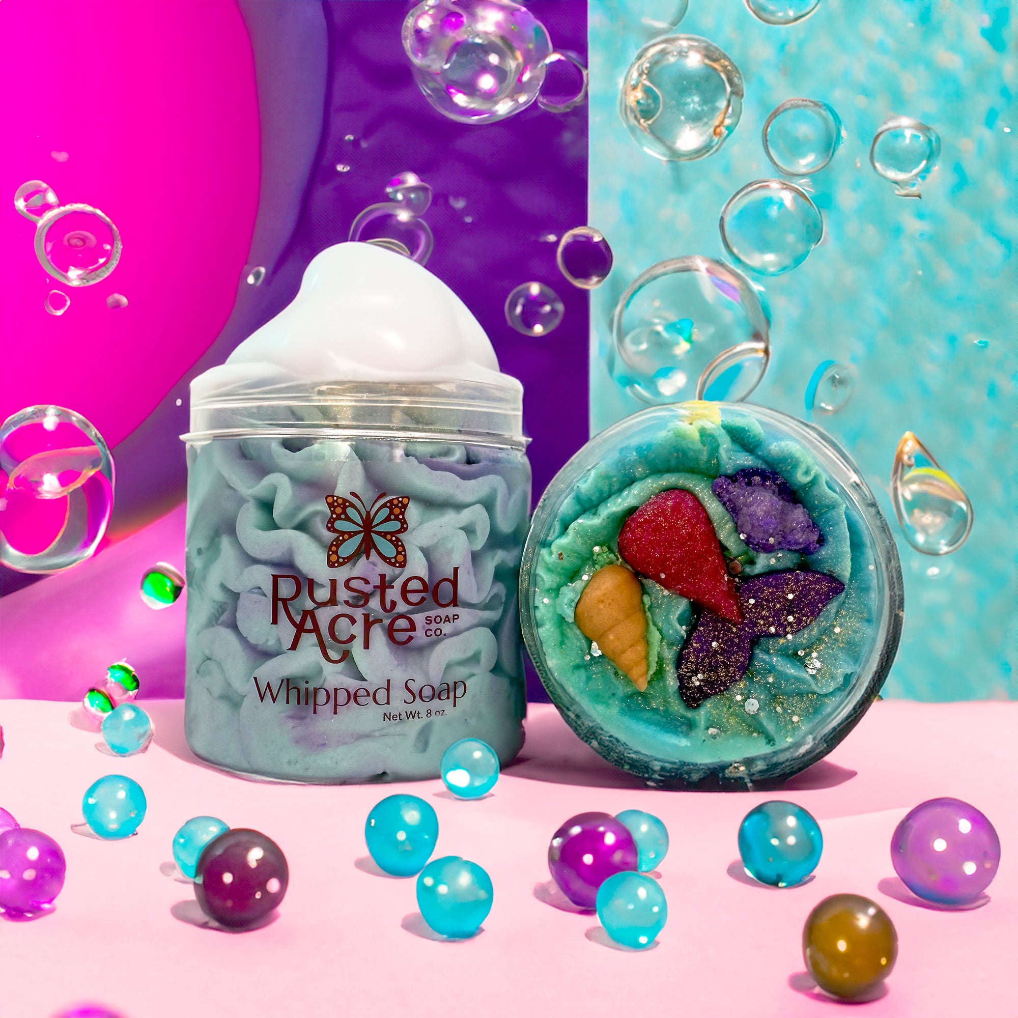 Two jars of Rusted Acre Soap Company’s Mermaid Kiss whipped soap front and top view in a lifestyle setting.