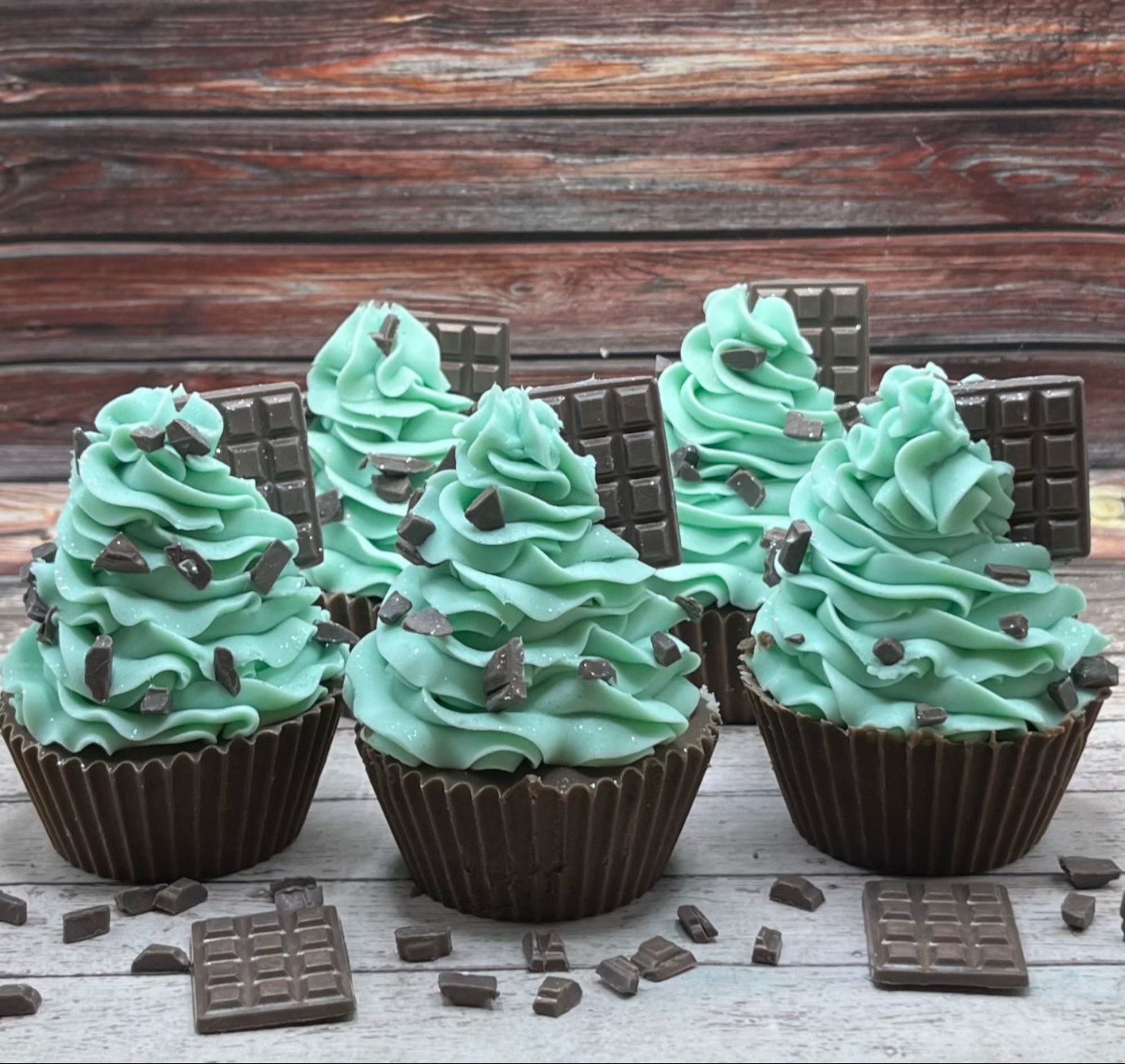 Multiple mint chocolate cupcake soaps displayed on a rustic wood background! 