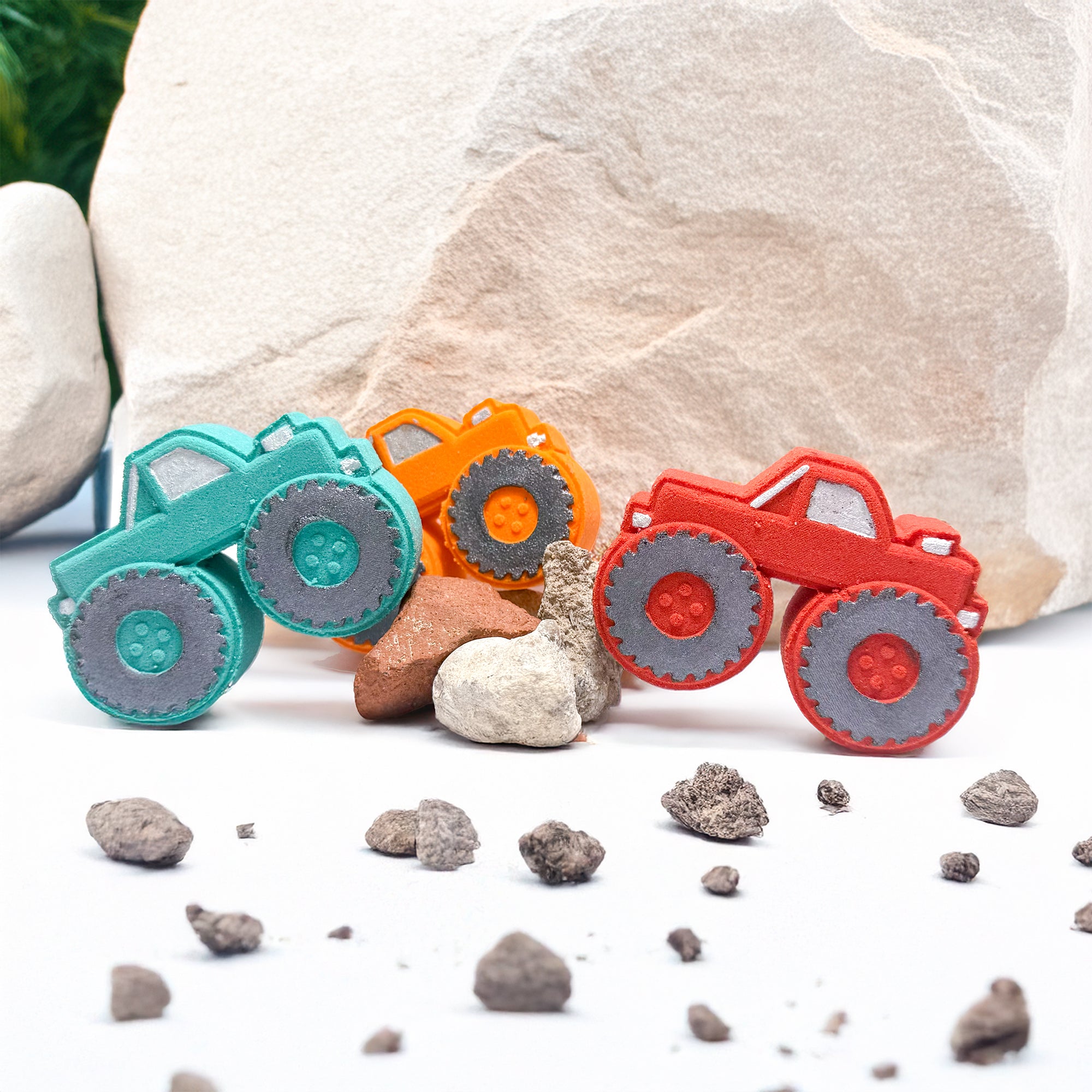 Three Monster Truck bath bombs on rocks. Made by Rusted Acre Soap Co
