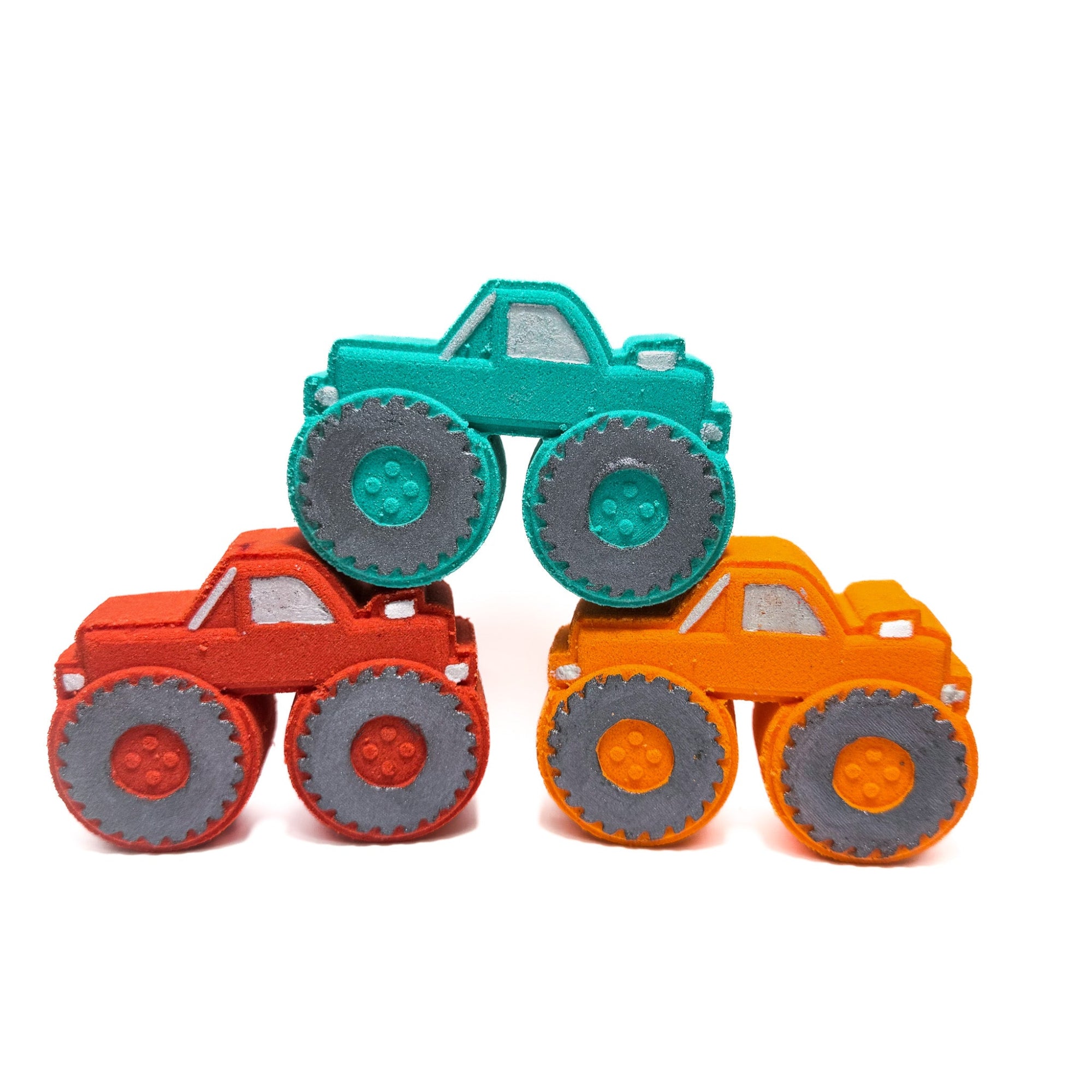 Three colored monster truck bath bombs handmade by Rusted Acre Soap Company. Colors are teal, red, and orange.