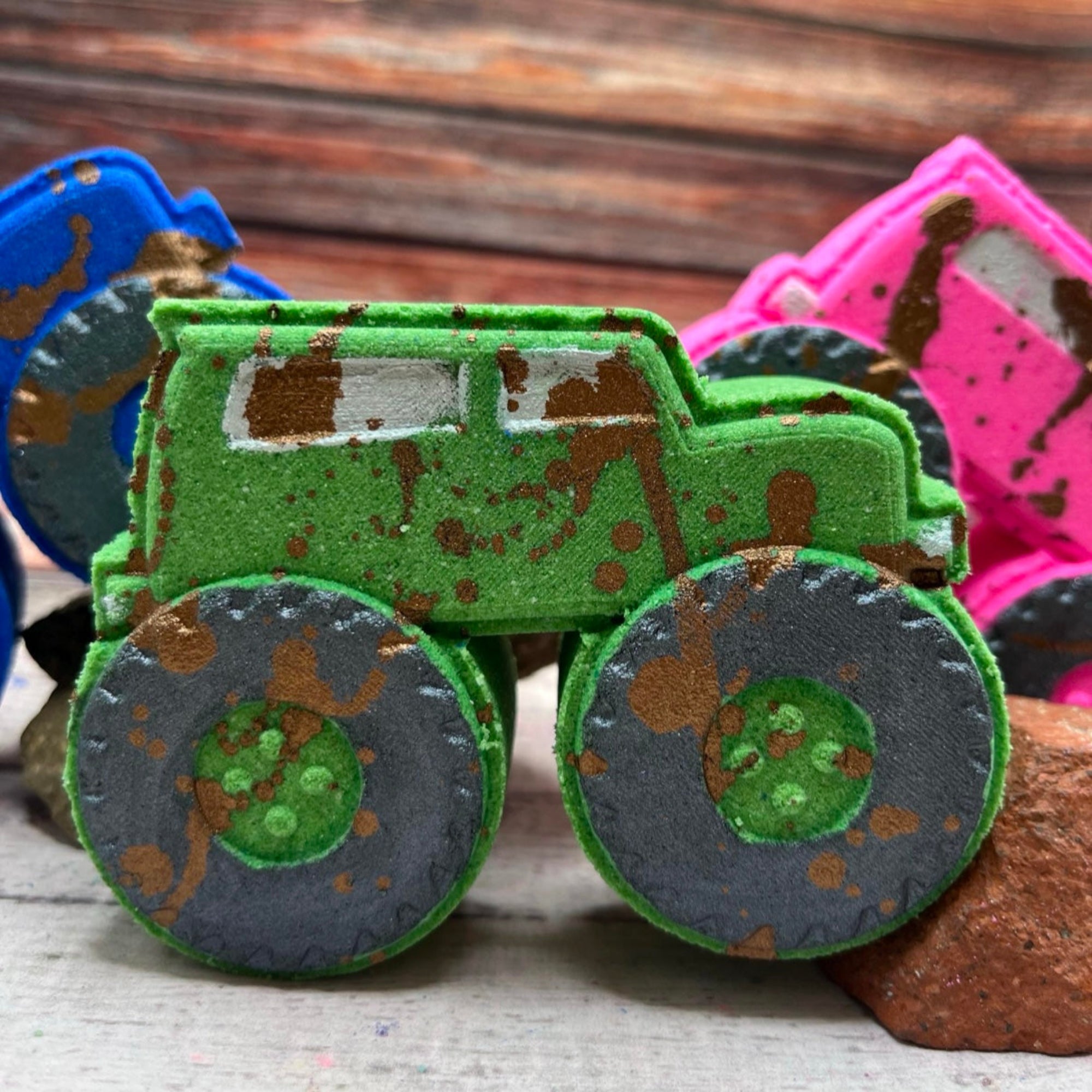 A green monster truck bath bomb with hand-painted black wheels and muddy brown splashes, hand painted to look like it just powered through the dirt. A fun bath bomb for kids and truck lovers.