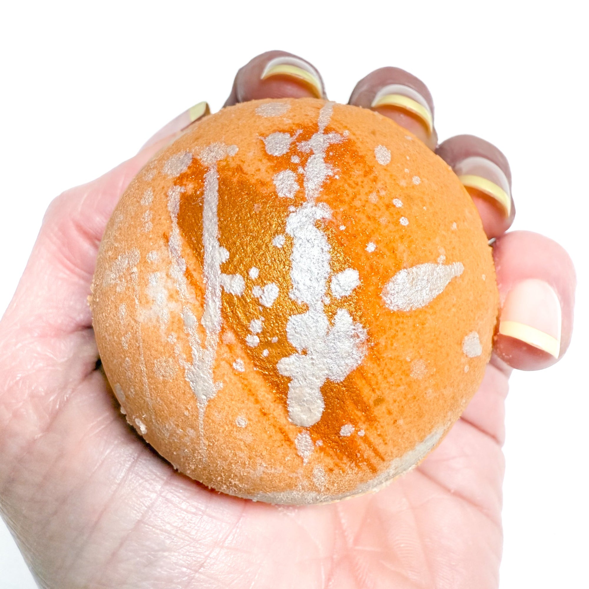 Round handmade orange and white swirled bath bomb scented with a creamy orange vanilla scent from Rusted Acre Soap Company. 