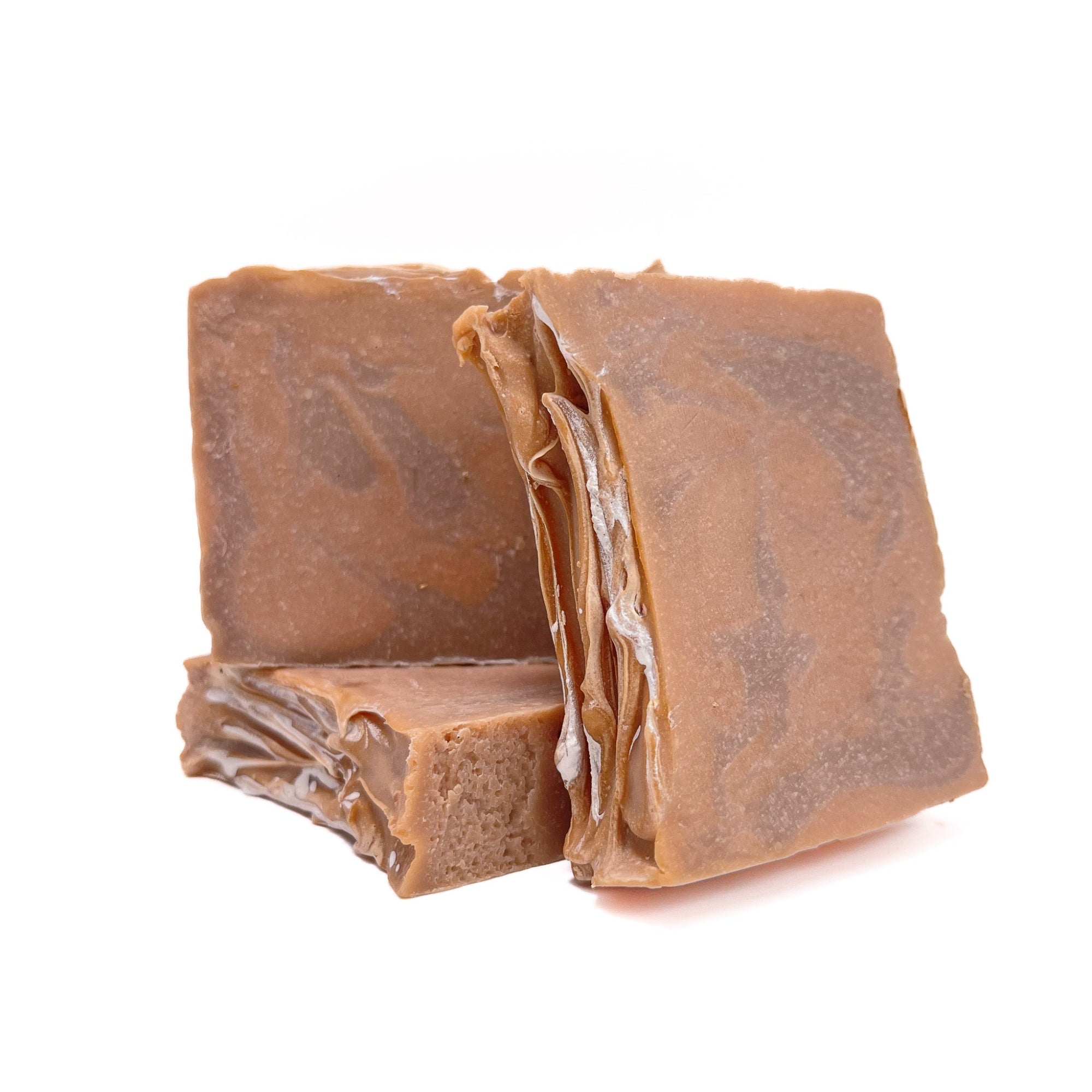 Three bars of light and dark orange swirled handmade soap, topped with a splash of silver.
