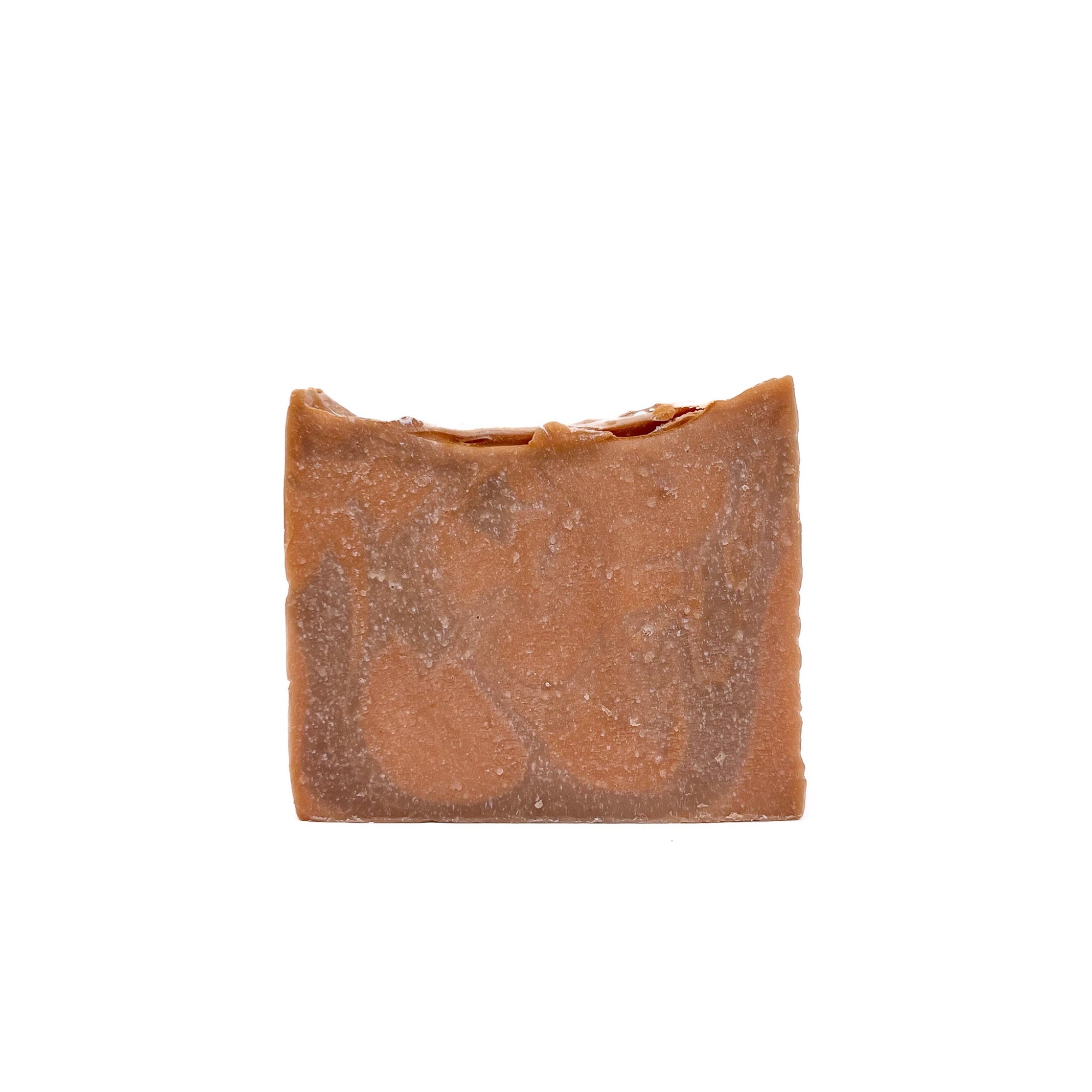 A bar of light and dark orange swirled handmade soap, topped with a splash of silver from Rusted Acre Soap Co.