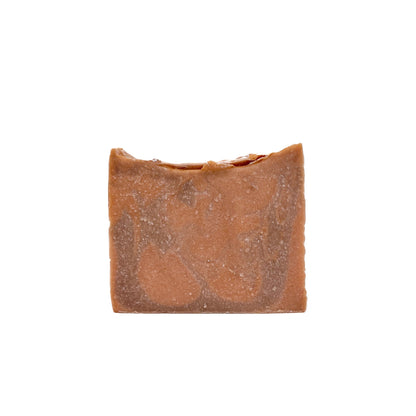 A bar of light and dark orange swirled handmade soap, topped with a splash of silver from Rusted Acre Soap Co.