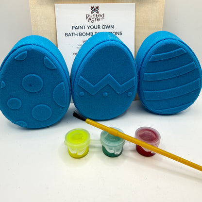 Three blue Easter Egg bath bomb kits with paint containers and a brush on a white background made by Rusted Acre Soap Co.