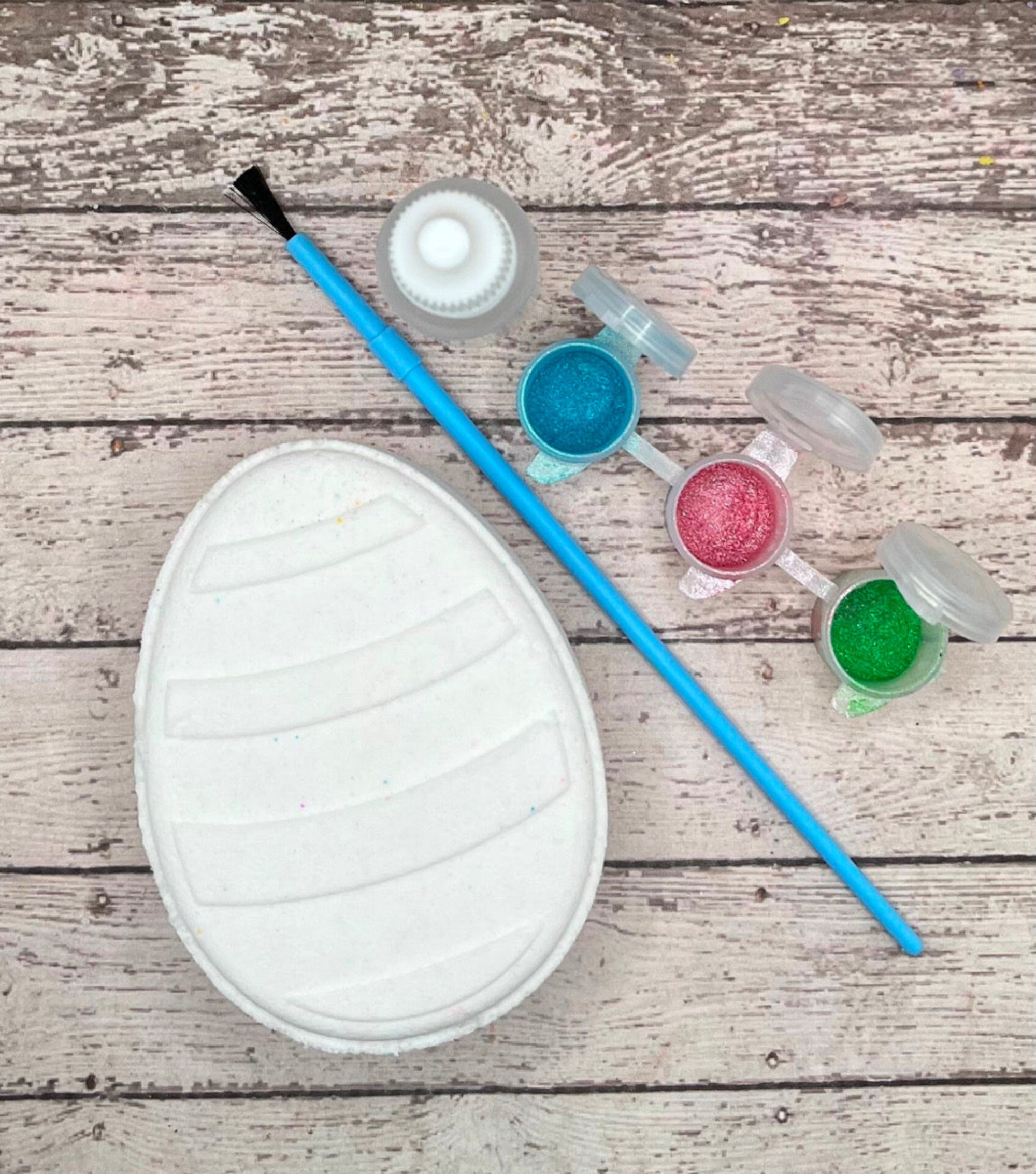 Paint your own easter egg kit with a stripe design, white bath bomb and painting supplies. Made by Rusted Acre Soap Co.